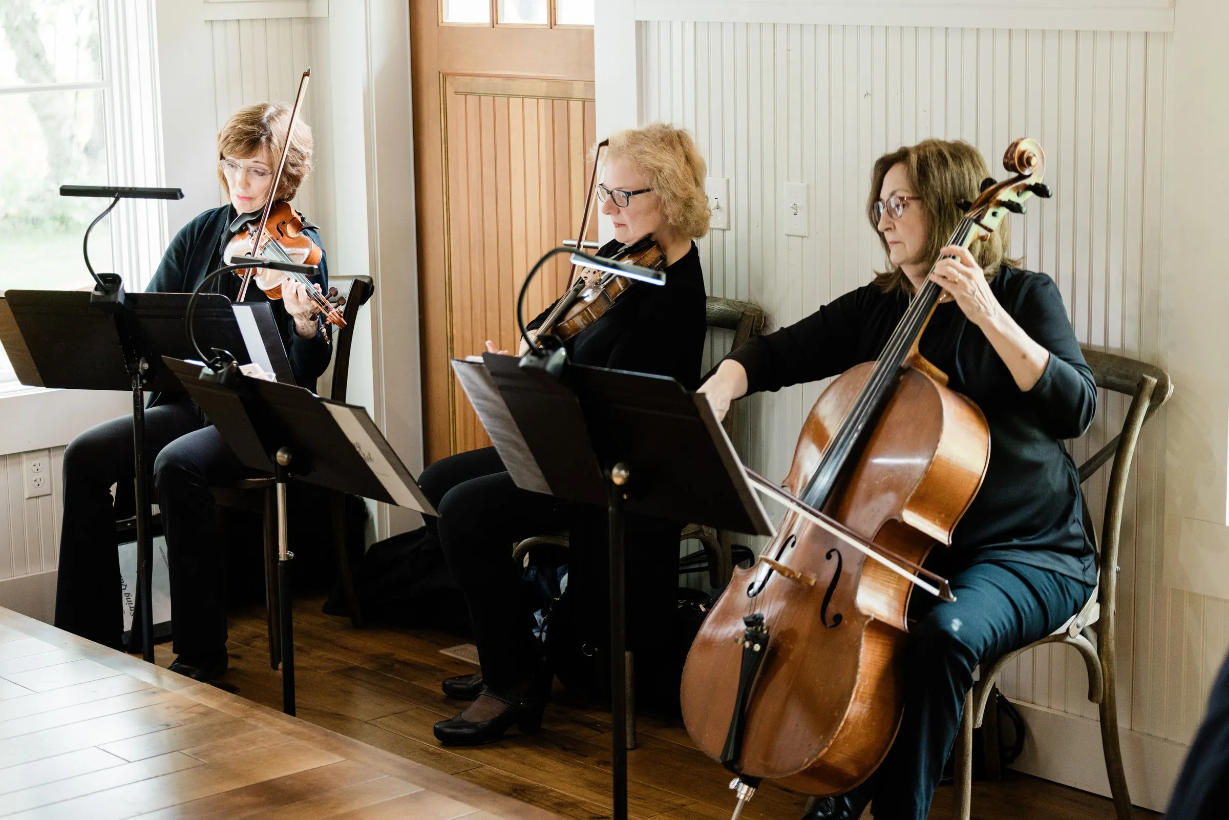 A string trio plays beside the Chapel windows — Tim Larsen Photography, Brainerd Lakes MN