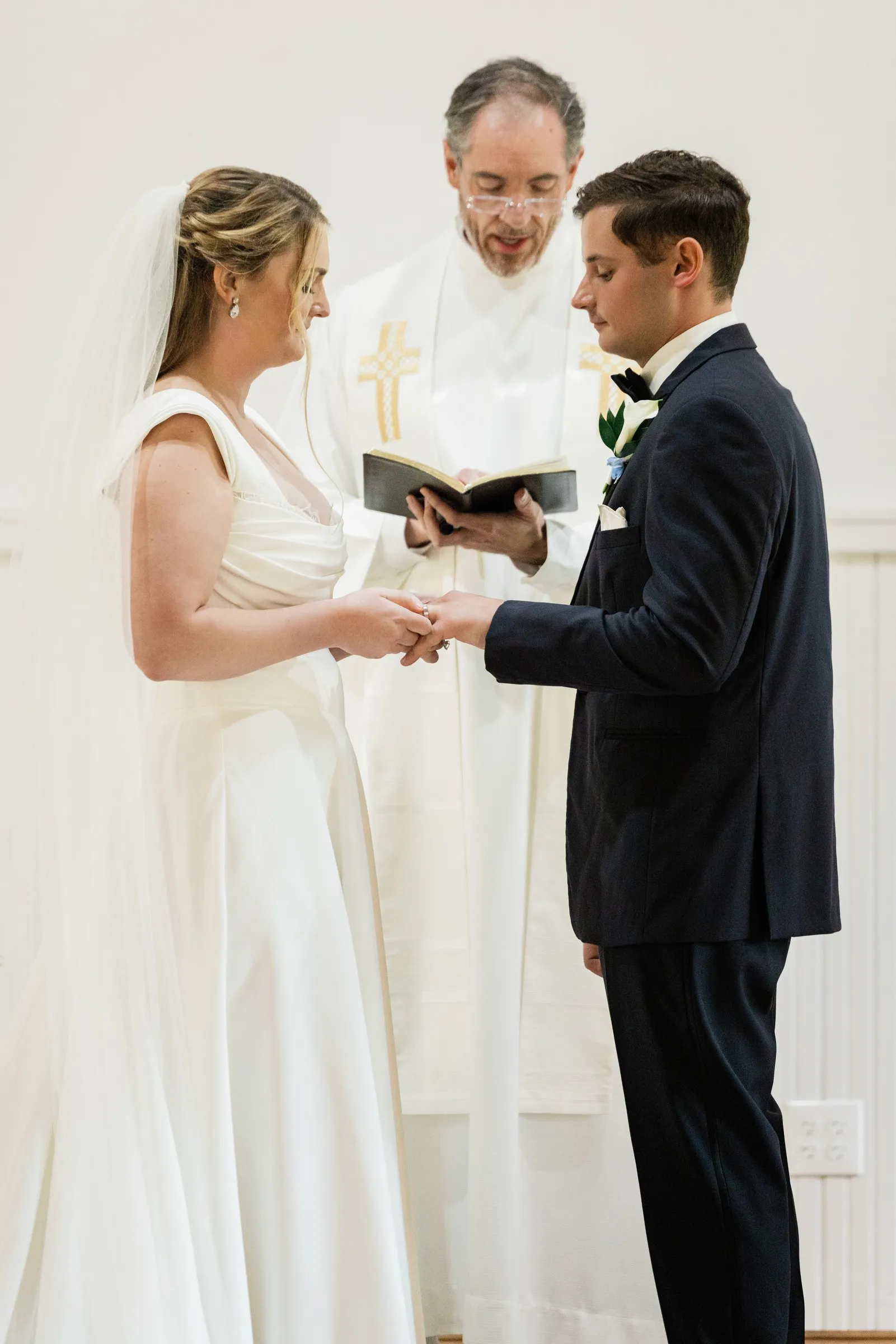 Lauren and Noah exchange rings while their military chaplain reads beside them — Tim Larsen Photography, Brainerd Lakes MN