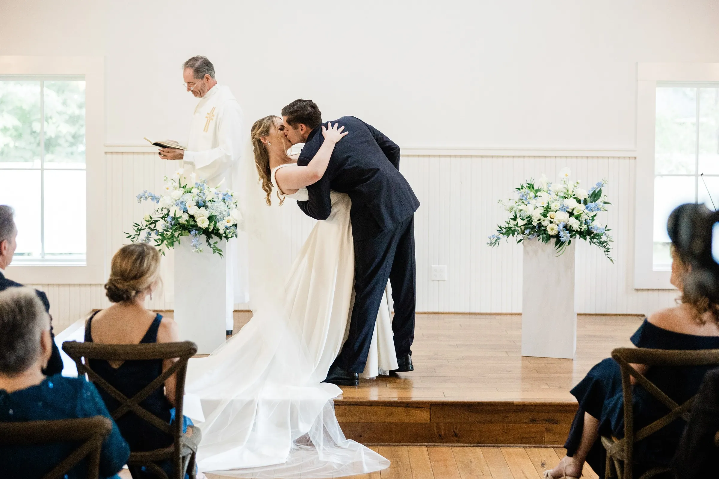 Noah dips Lauren for their first kiss during the Chapel ceremony — Tim Larsen Photography, Brainerd Lakes MN