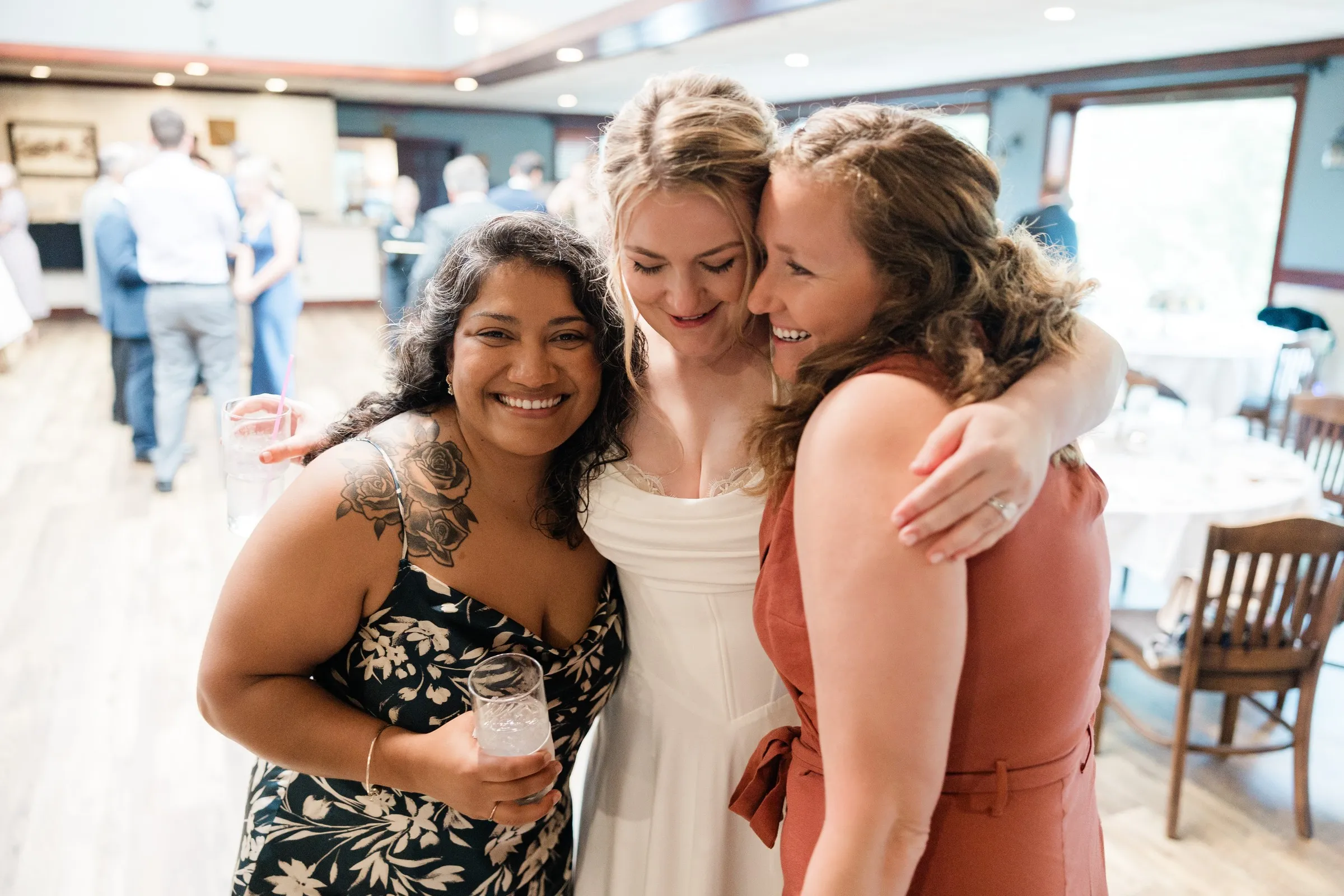 Lauren shares a hug with two guests at the reception — Tim Larsen Photography, Brainerd Lakes MN
