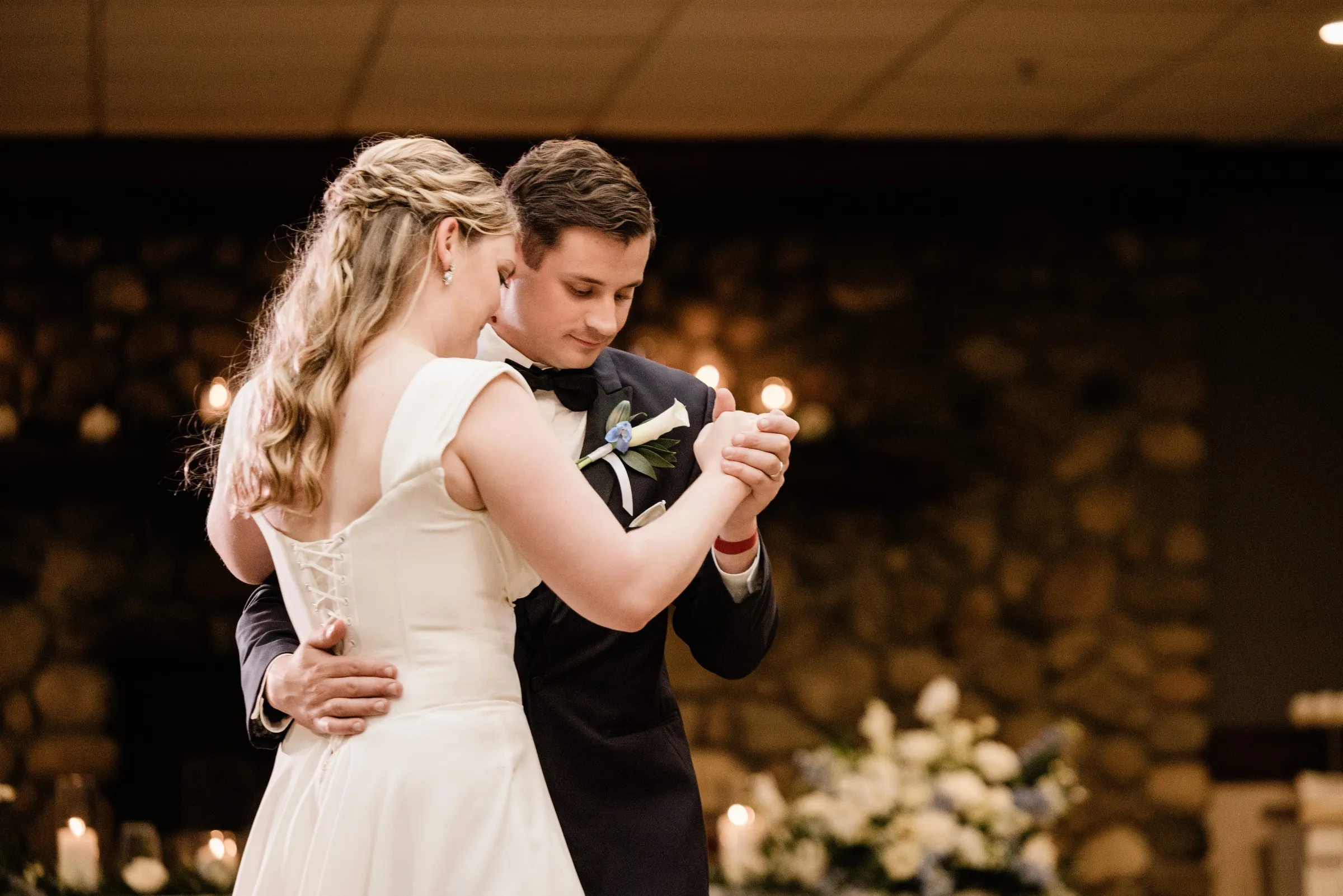 Lauren and Noah dance close together in front of the stone fireplace — Tim Larsen Photography, Brainerd Lakes MN