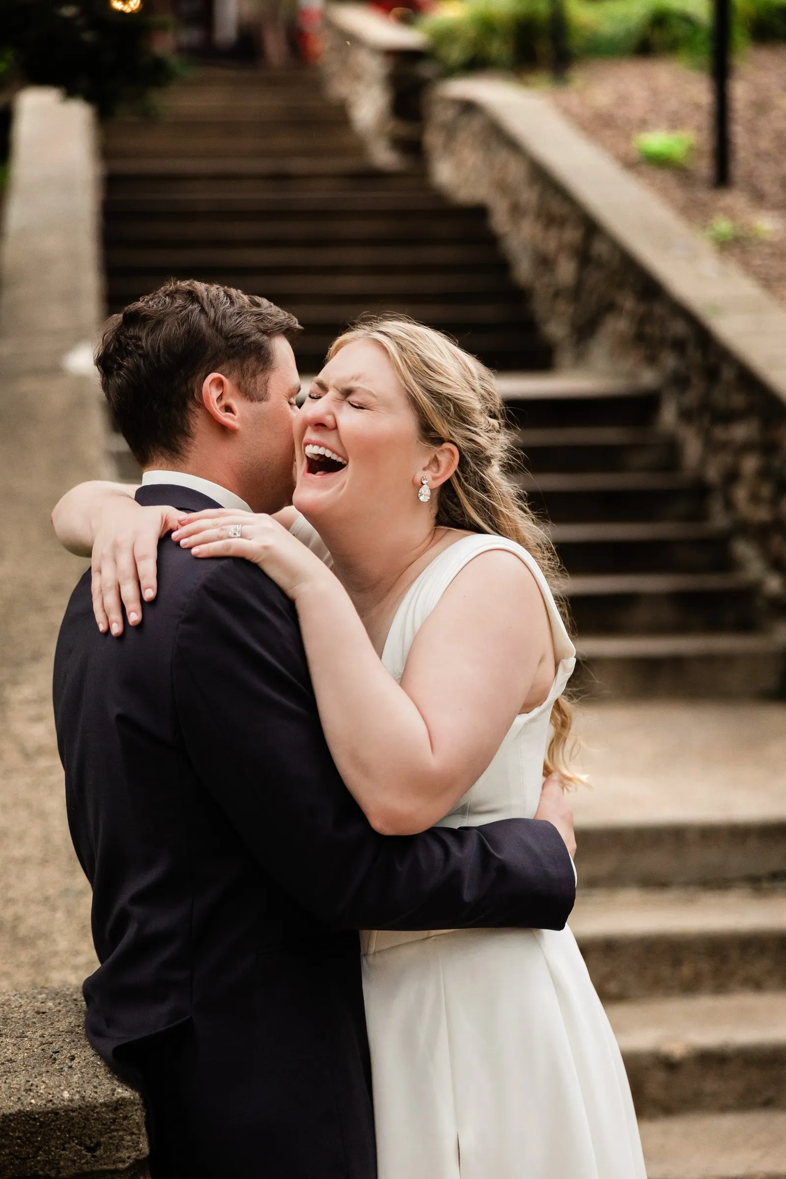 Lauren laughs with her arms around Noah beside the stone staircase — Tim Larsen Photography, Brainerd Lakes MN