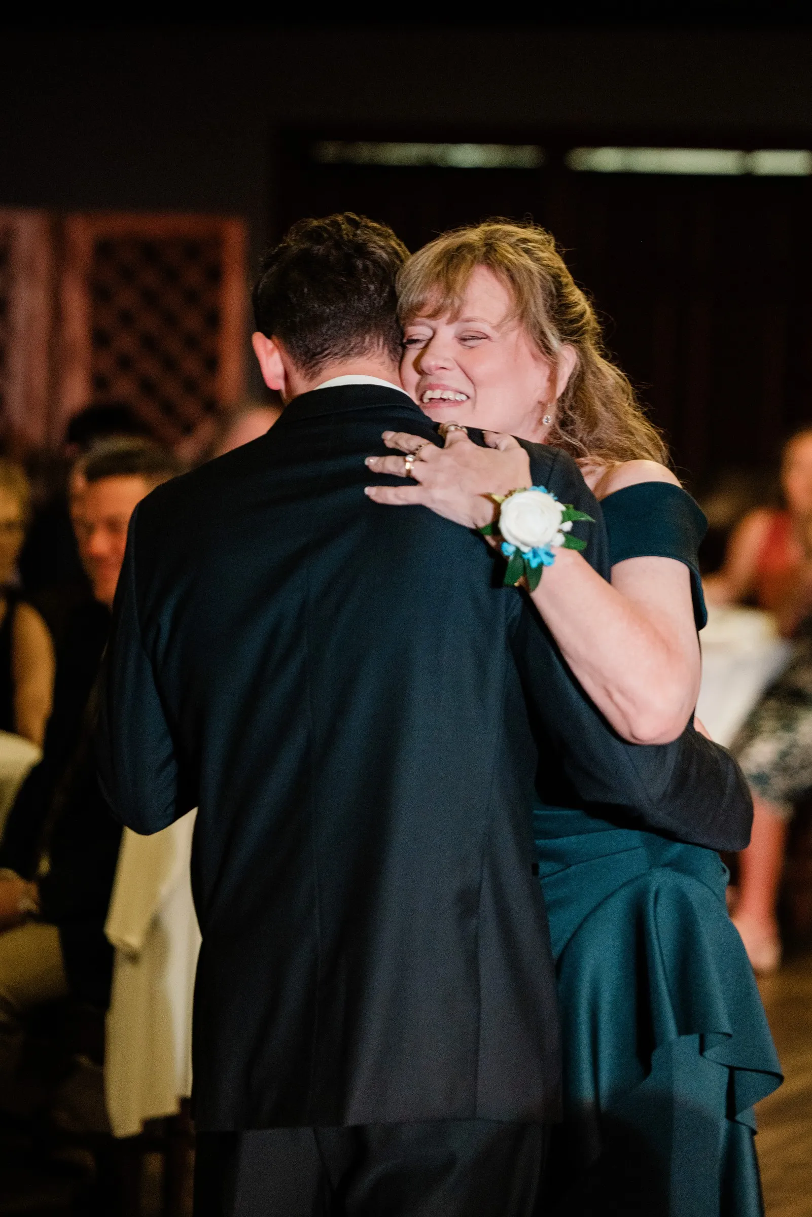 Noah embraces a smiling woman in a navy dress during a reception dance — Tim Larsen Photography, Brainerd Lakes MN