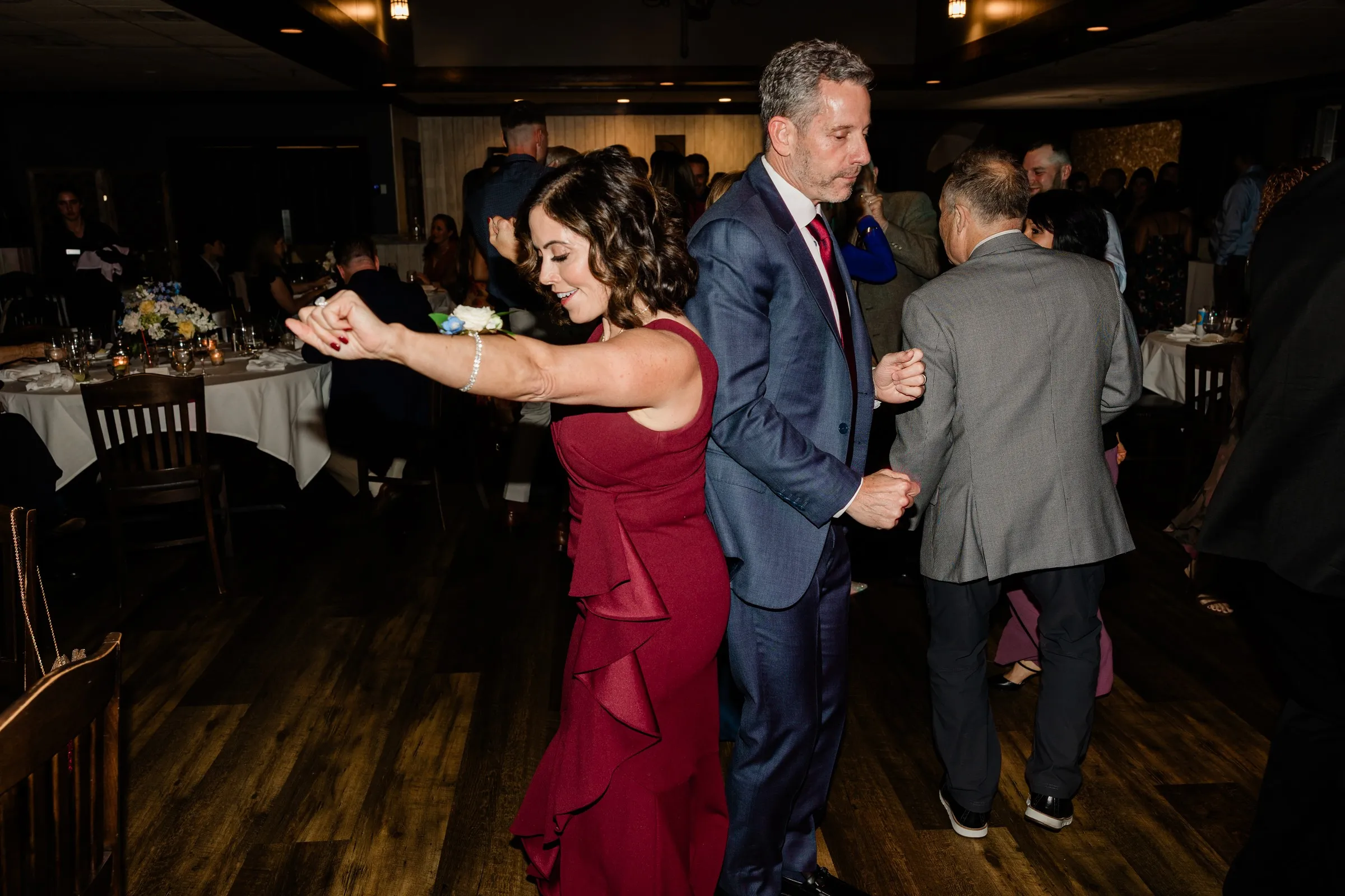 Guests dance together beneath the timber beams at the wedding reception — Tim Larsen Photography, Brainerd Lakes MN