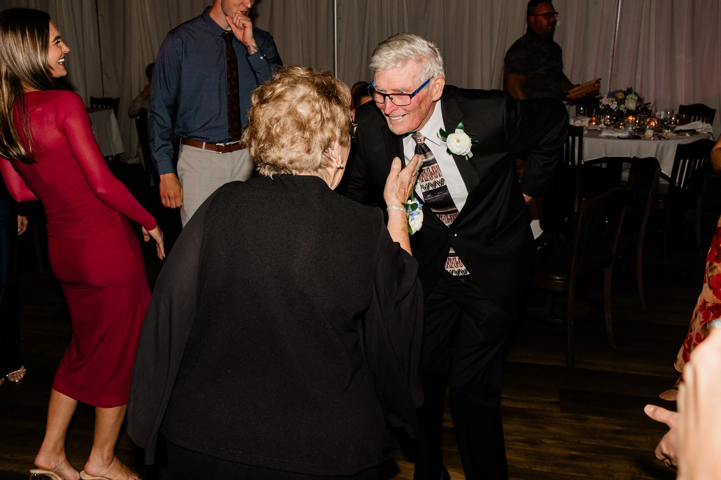 A smiling man in glasses dances with a woman at the reception — Tim Larsen Photography, Brainerd Lakes MN
