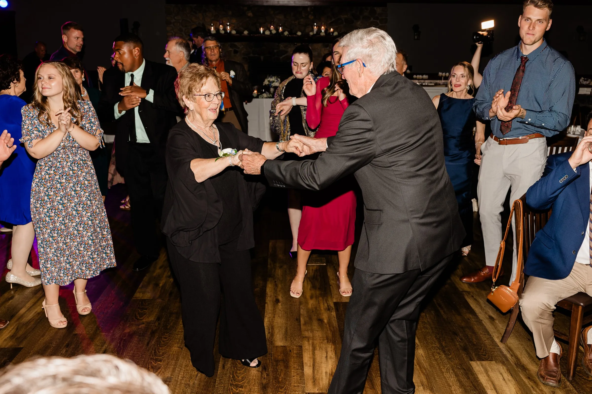 Two guests dance together as others gather around the Heritage Room dance floor — Tim Larsen Photography, Brainerd Lakes MN