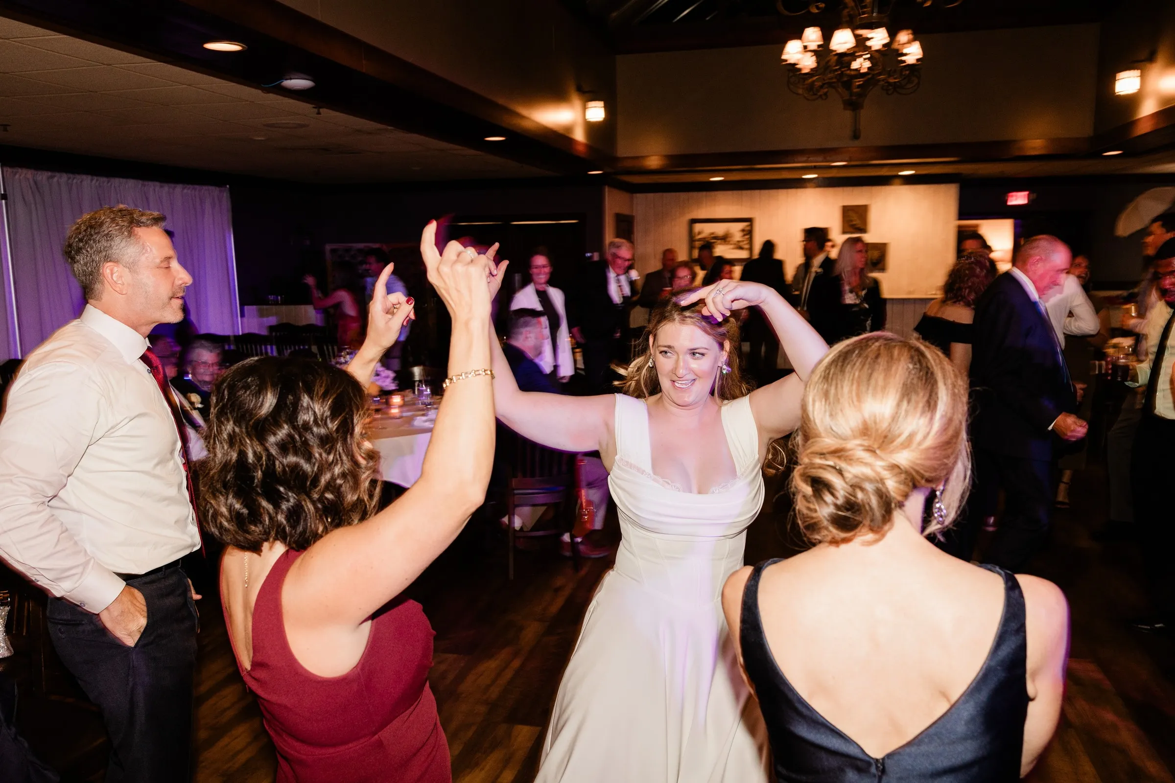 Lauren dances among guests with their hands raised — Tim Larsen Photography, Brainerd Lakes MN