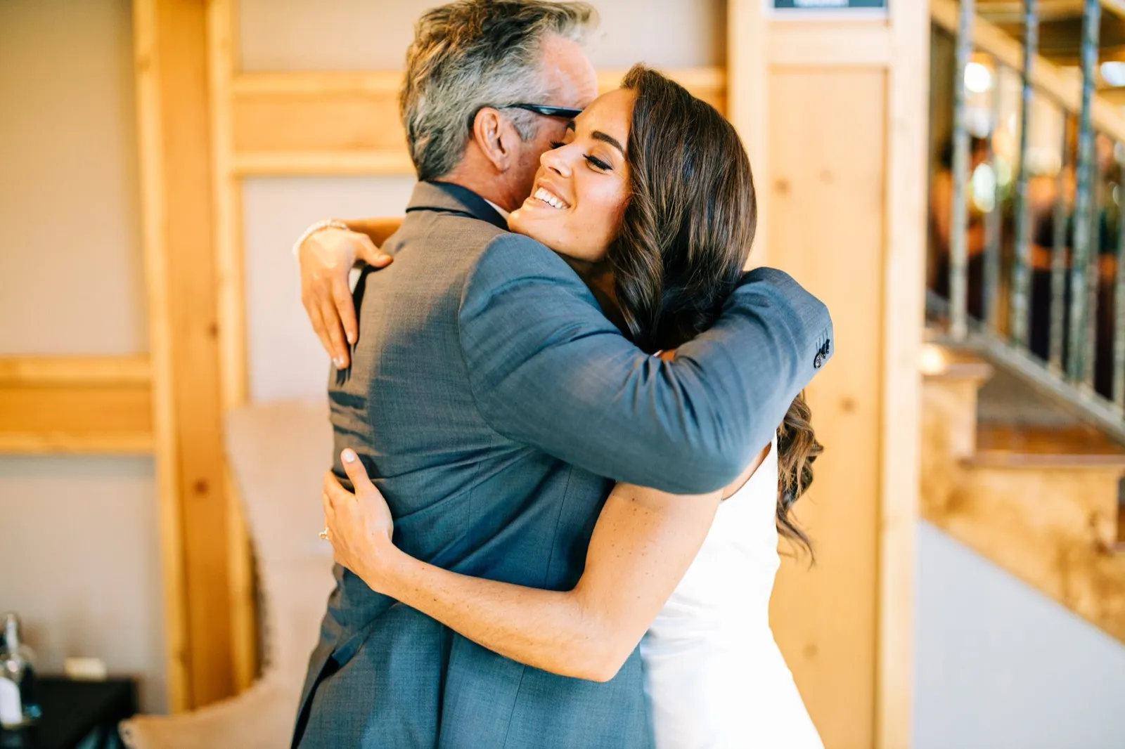 Madison beams while embracing her father in the warmly lit timber lodge interior at Madden's on Gull Lake — Tim Larsen Photography, Brainerd Lakes MN