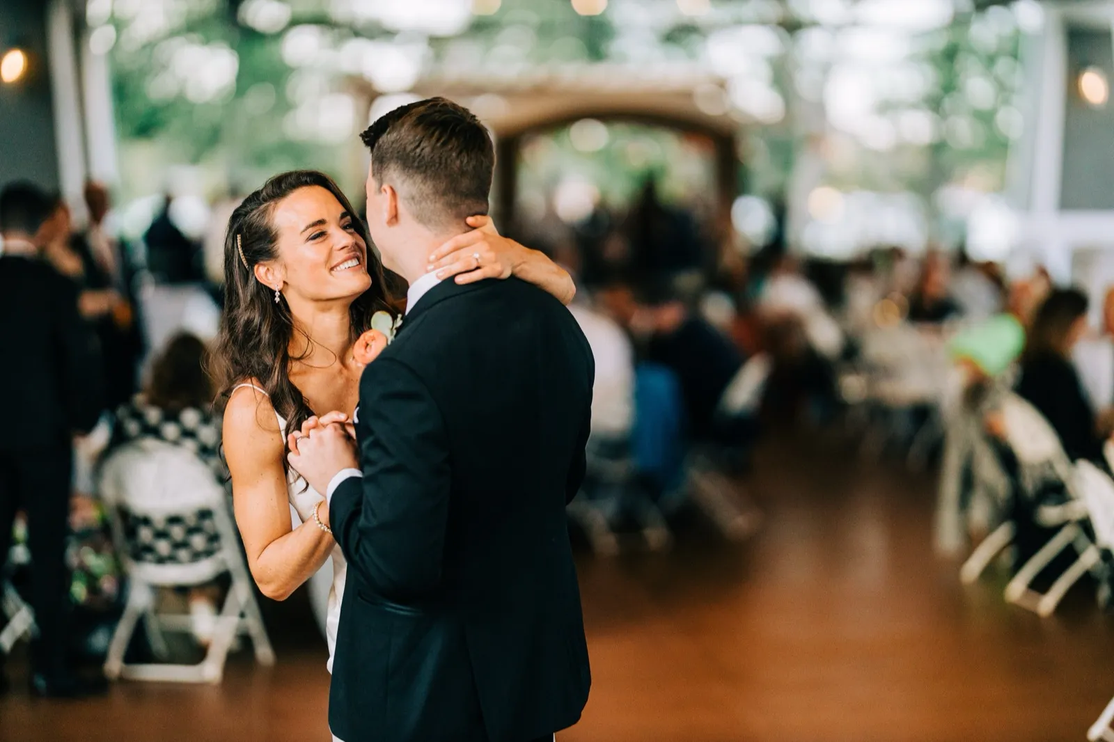 Madison smiles up at Josh, her hand on the back of his neck, during their first dance in the Madden's reception pavilion — Tim Larsen Photography, Brainerd Lakes MN
