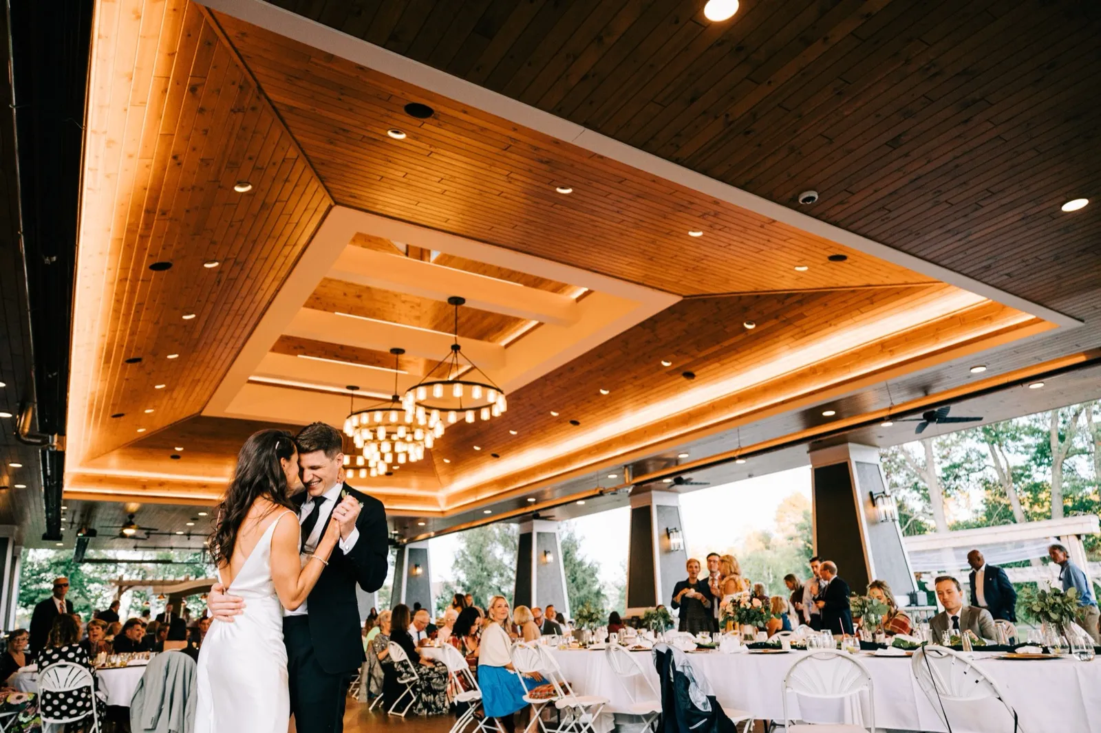 Madison and Josh share a quiet first dance beneath the soaring wood-paneled ceiling of the Madden's pavilion — Tim Larsen Photography, Brainerd Lakes MN