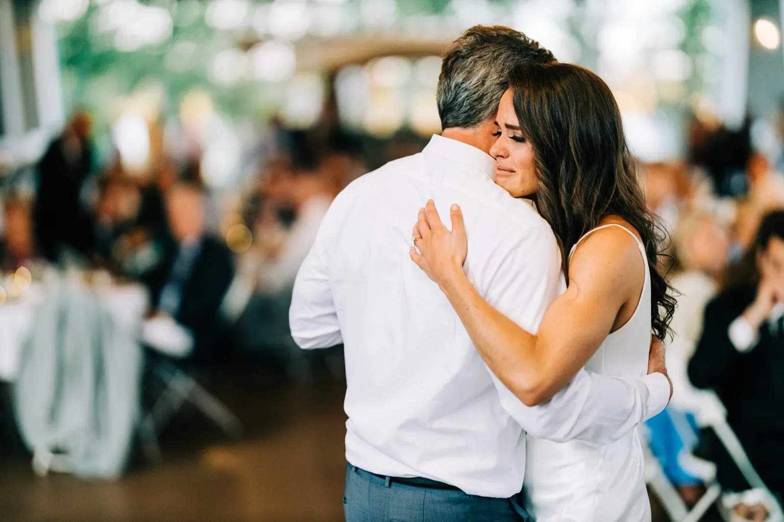 Madison rests her face on her father's shoulder, eyes closed and tears welling, as they share a dance — Tim Larsen Photography, Brainerd Lakes MN
