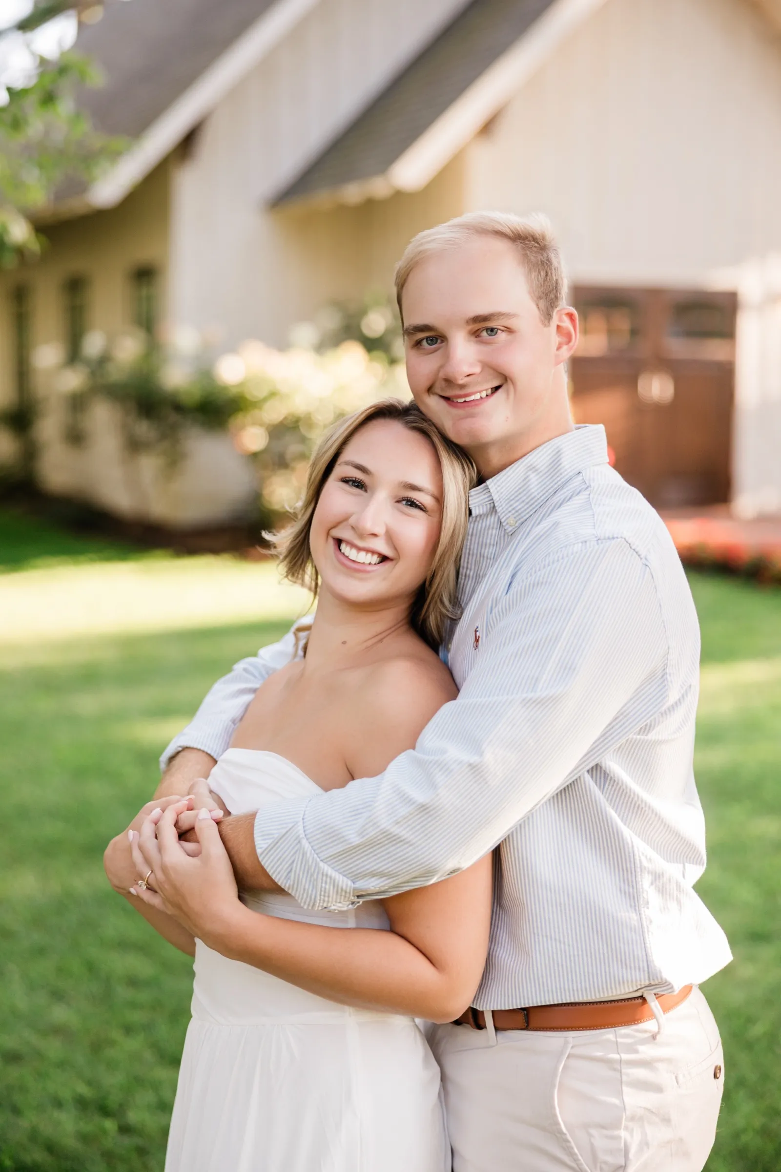 Adam wraps his arms around Olivia from behind on the lawn, both smiling — Tim Larsen Photography