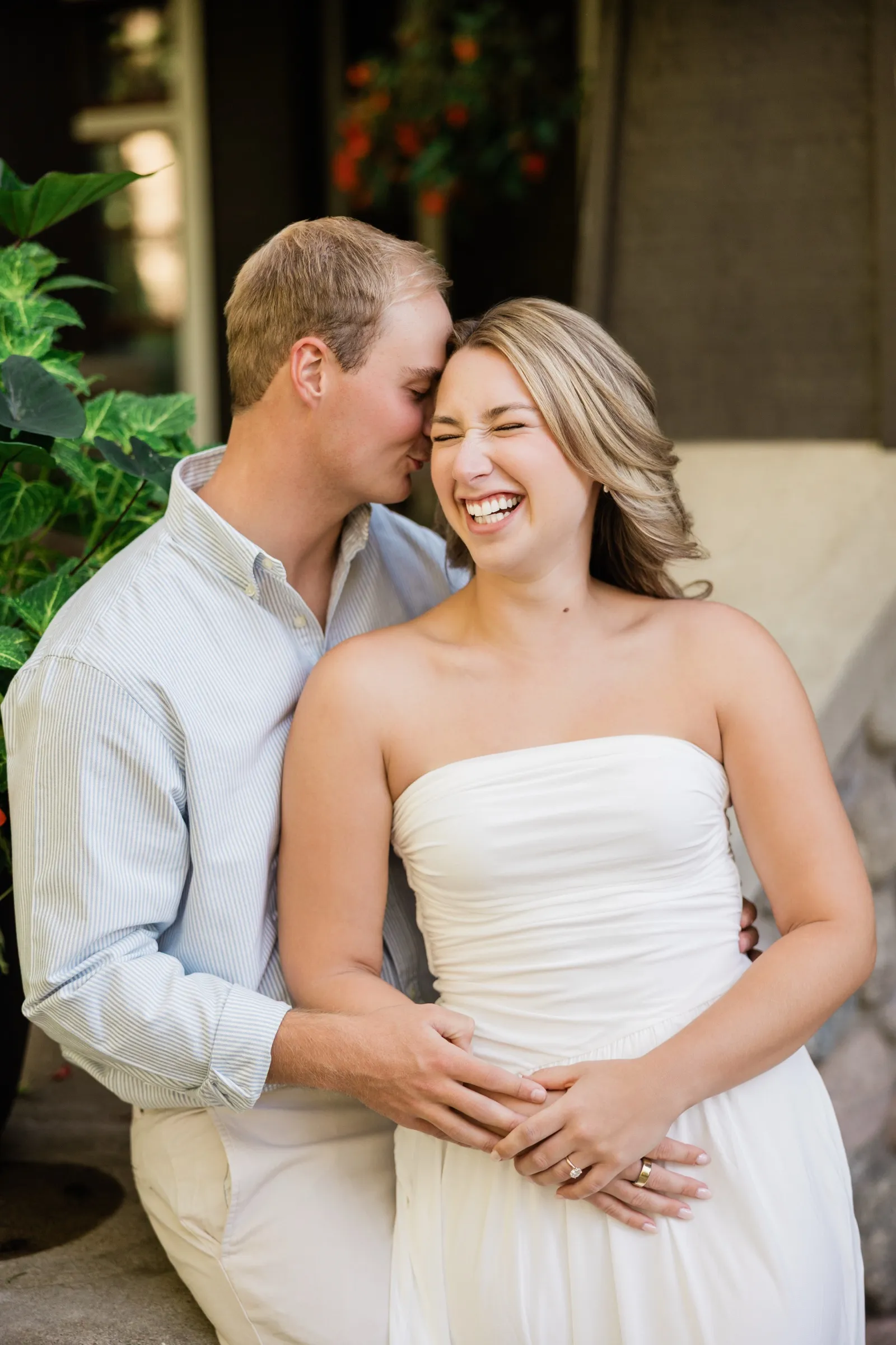 Olivia laughs with her eyes squeezed shut while Adam kisses her temple, their hands stacked at her waist — Tim Larsen Photography