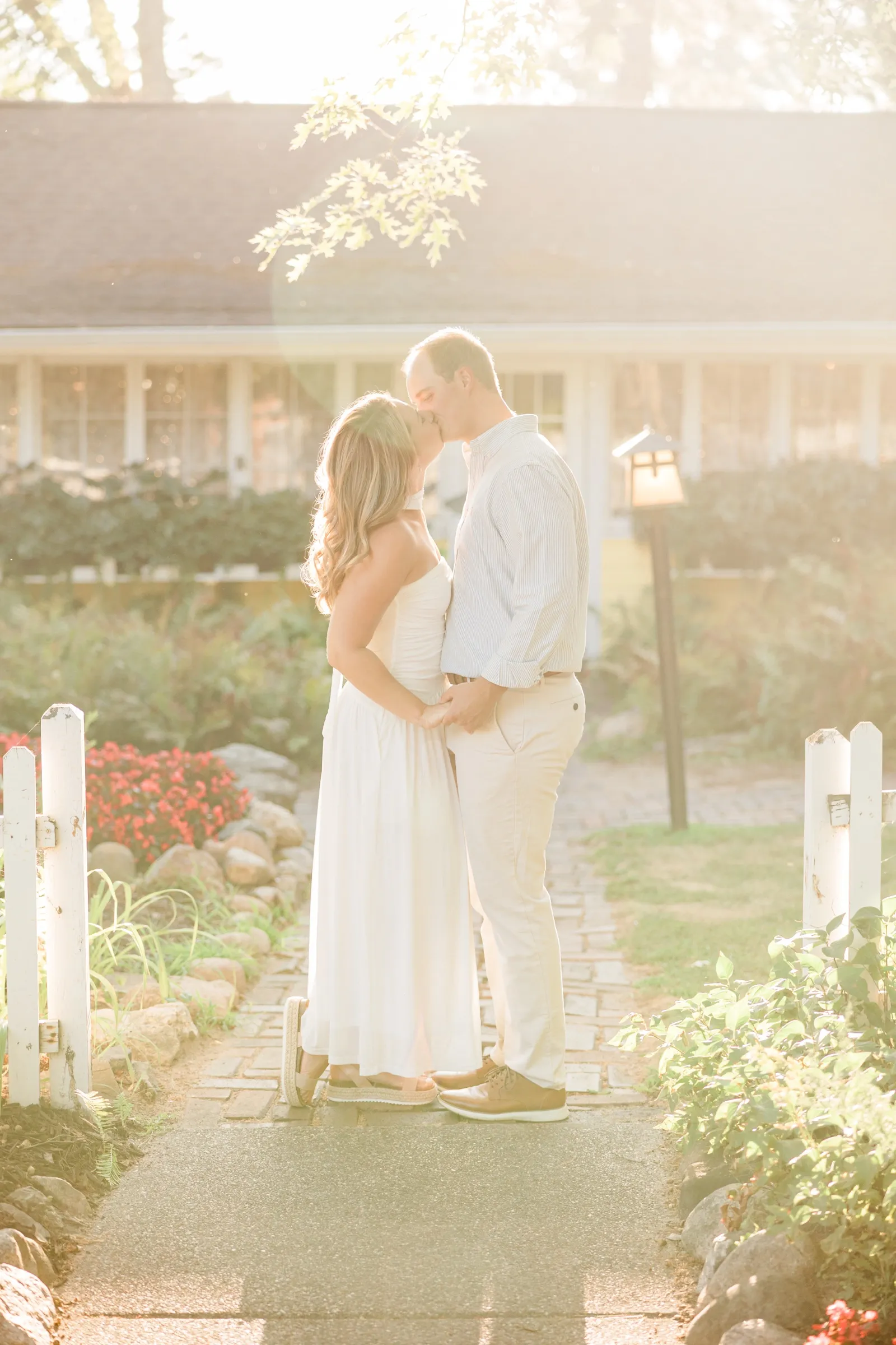 Olivia and Adam kiss in hazy golden backlight at the garden gate — Grand View Lodge, Nisswa MN — Tim Larsen Photography
