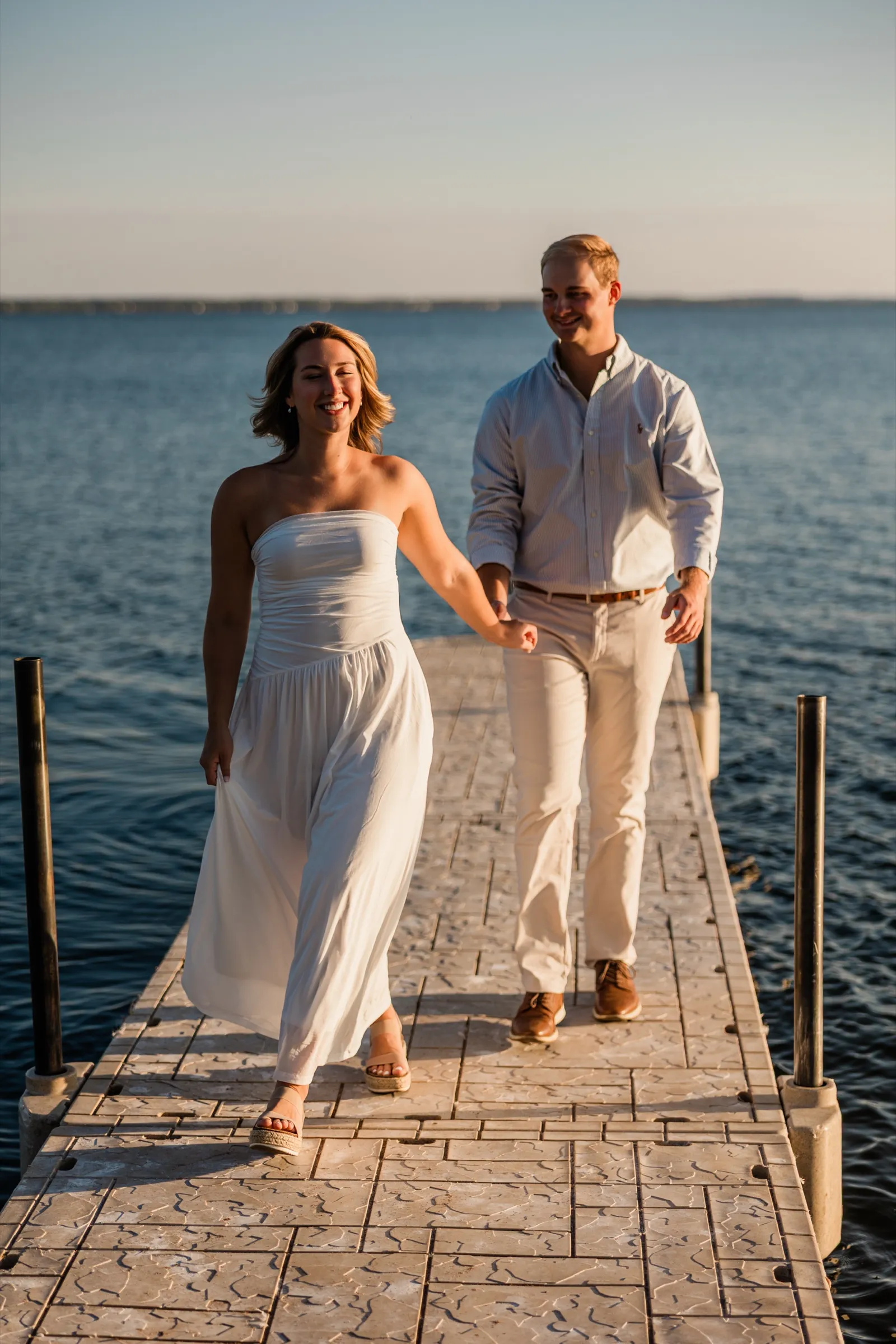 Olivia laughs as she and Adam walk the Gull Lake dock in golden evening light — Tim Larsen Photography