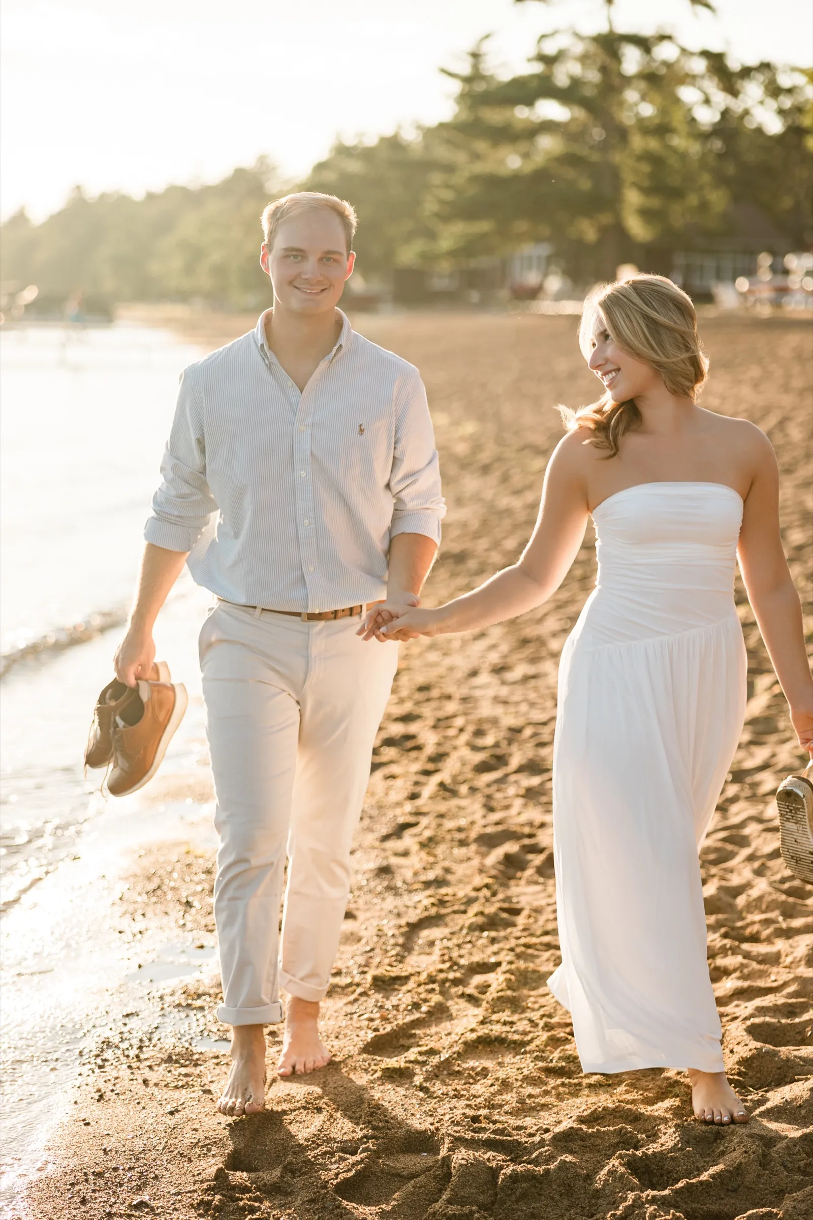 Olivia and Adam walk barefoot toward the camera on the Gull Lake beach at sunset — Tim Larsen Photography