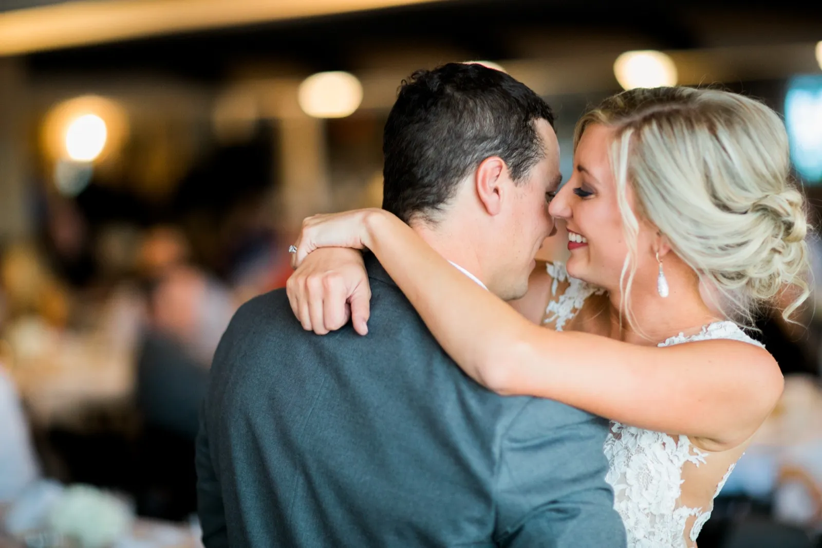 The bride smiles with her eyes closed as she leans her face toward the groom during their first dance, her arms wrapped around his shoulders. — Tim Larsen Photography, Brainerd Lakes MN
