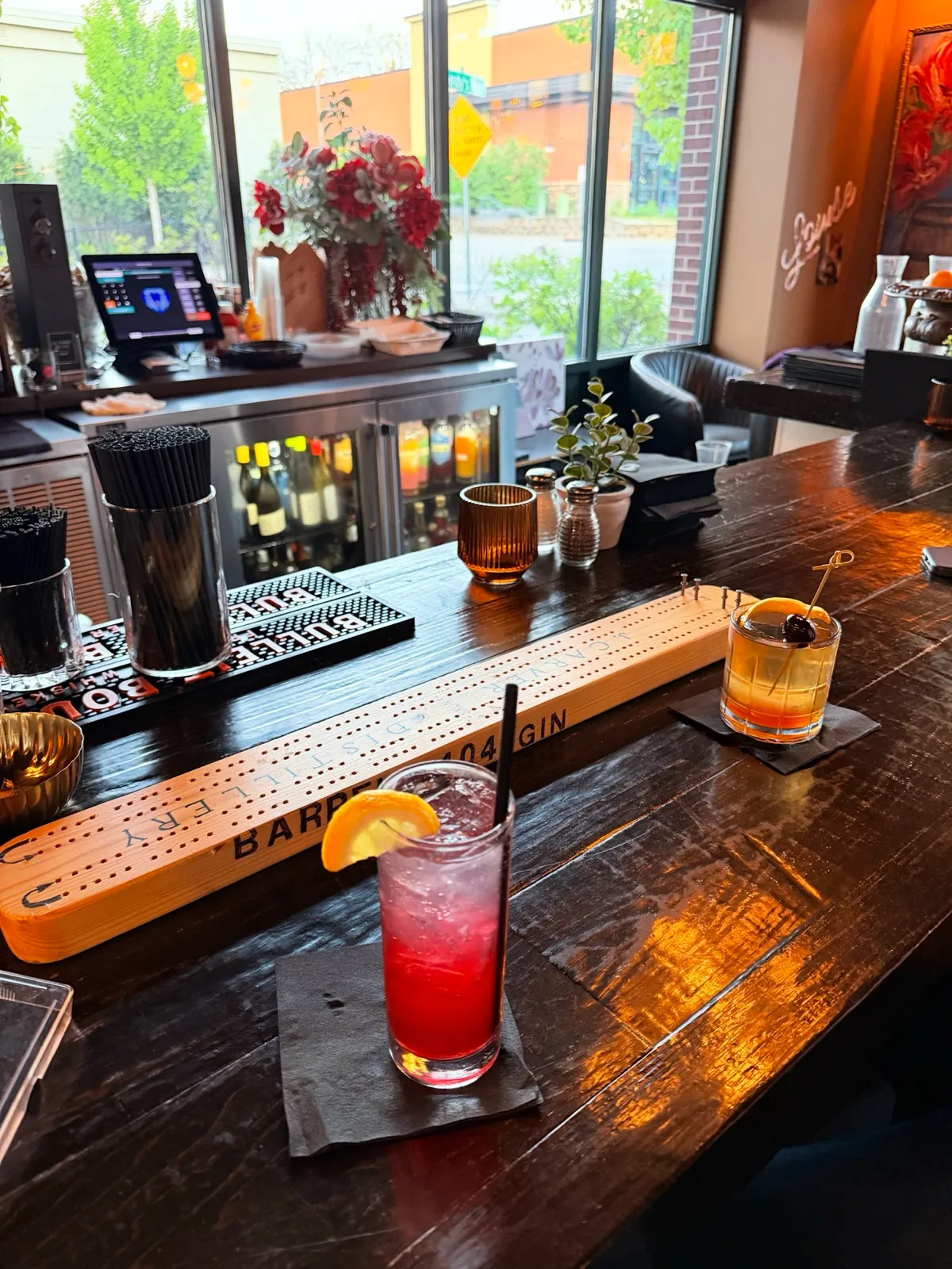 A long wooden cribbage board and two cocktails on a bar table where Abby and Anthony celebrated after the session — Tim Larsen Photography