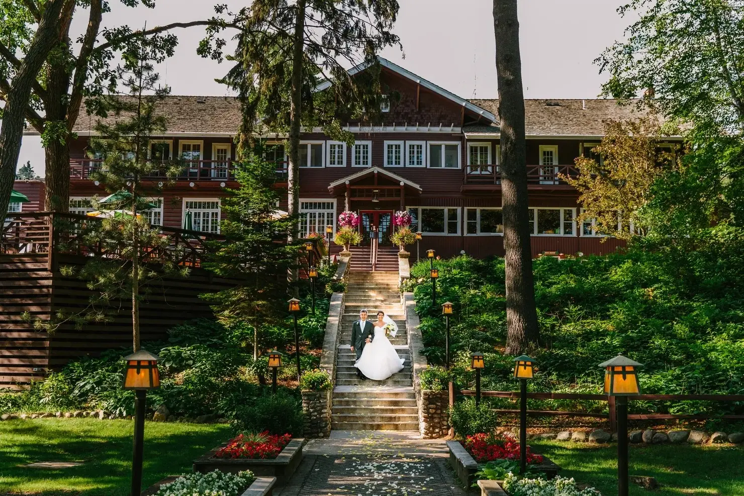 Bride at the base of Grand View Lodge’s Historic Main Lodge terrace, lanterns flanking the path — Tim Larsen Photography, Brainerd Lakes MN