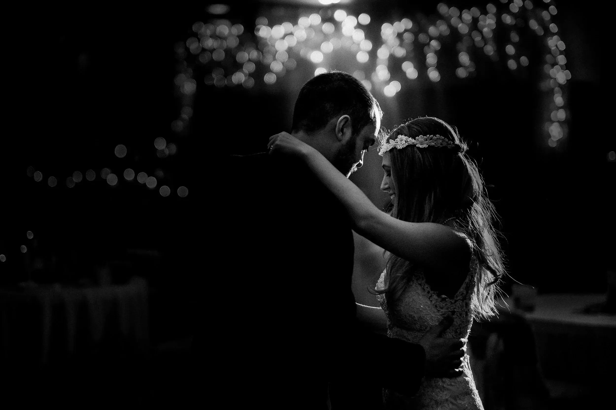 Black-and-white first dance framed by a curtain of twinkle lights — Tim Larsen Photography, Brainerd Lakes MN