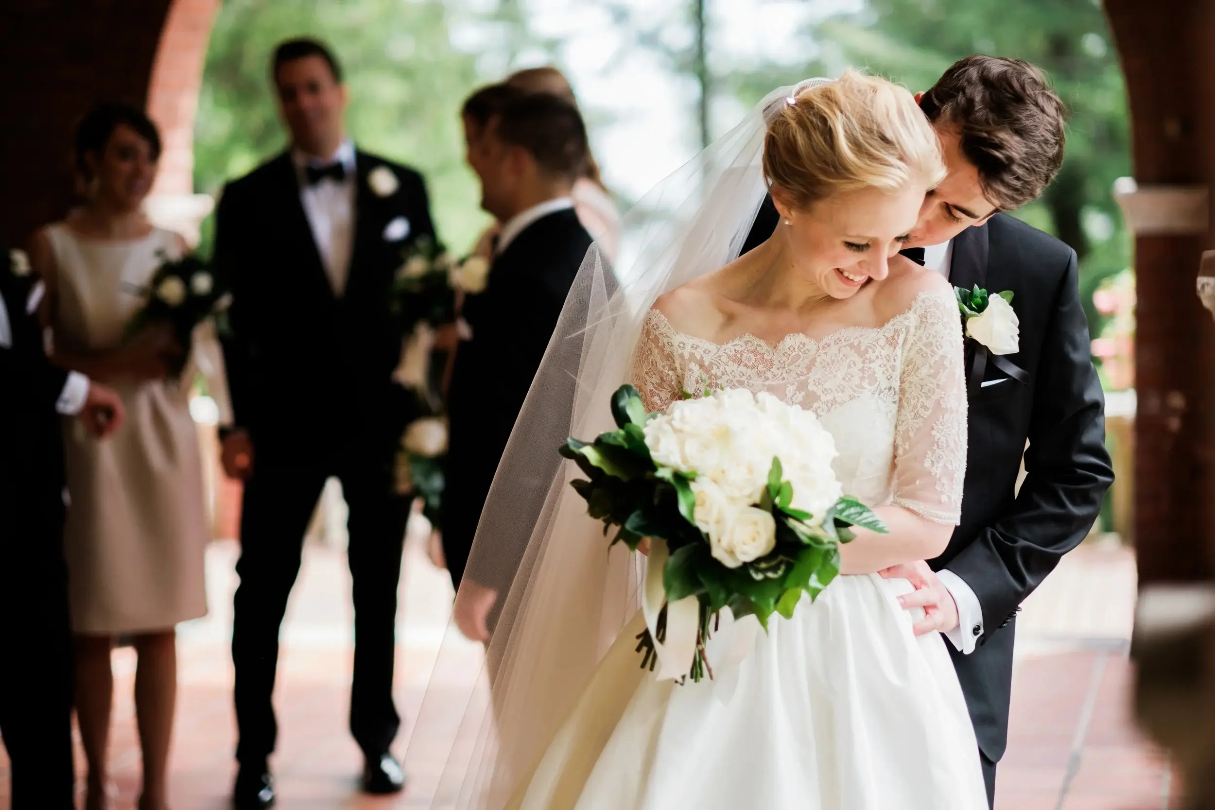 Bride and groom in an intimate embrace after the ceremony — lace-sleeved dress and a full white rose bouquet — Tim Larsen Photography, Brainerd Lakes MN