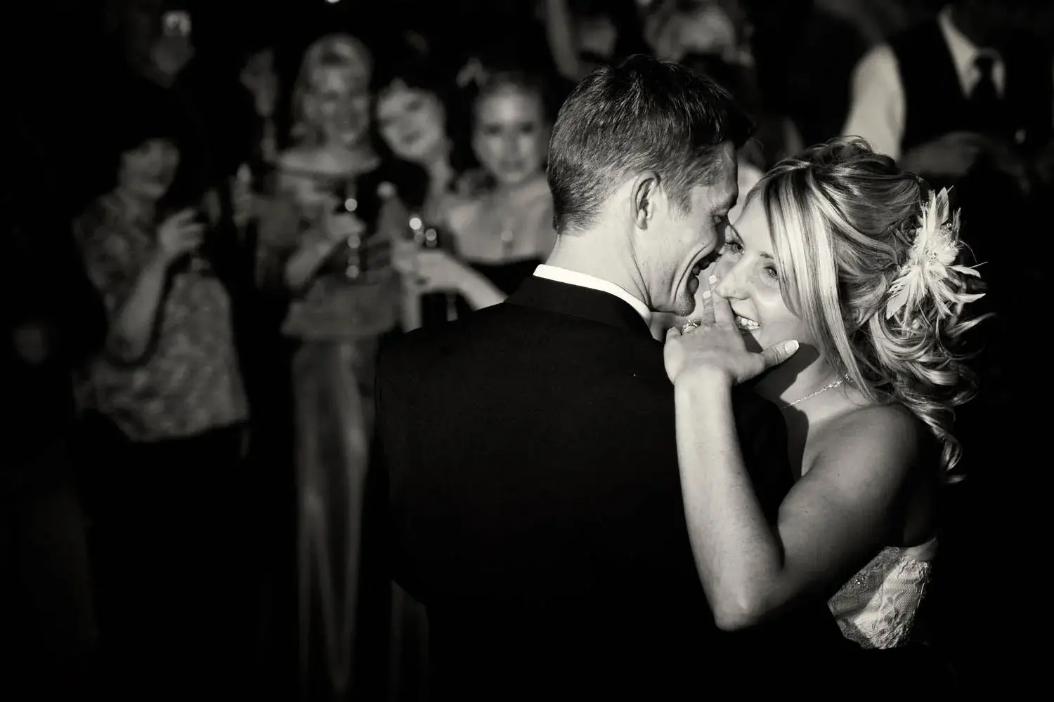 Black-and-white first dance, soft sepia, wedding party watching from the edges — Tim Larsen Photography, Brainerd Lakes MN
