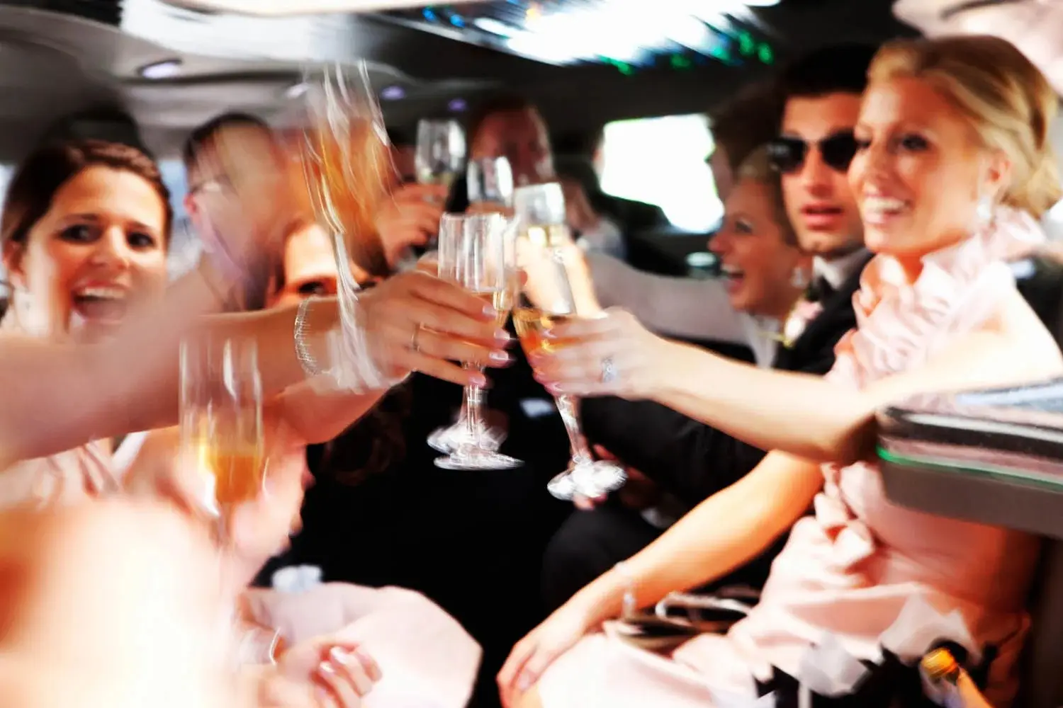 Motion-blurred limo toast — wedding party mid-clink of champagne flutes — Tim Larsen Photography, Brainerd Lakes MN