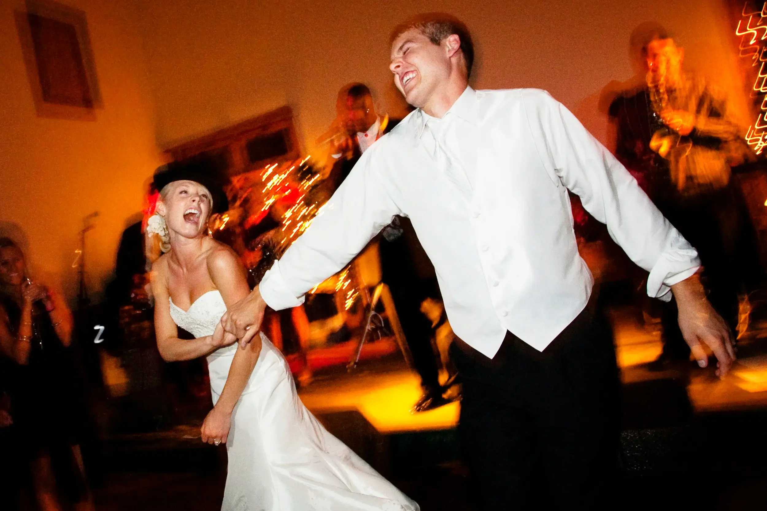 Bride and groom mid-spin on a tungsten-lit dance floor, sparks flying behind them — Tim Larsen Photography, Brainerd Lakes MN