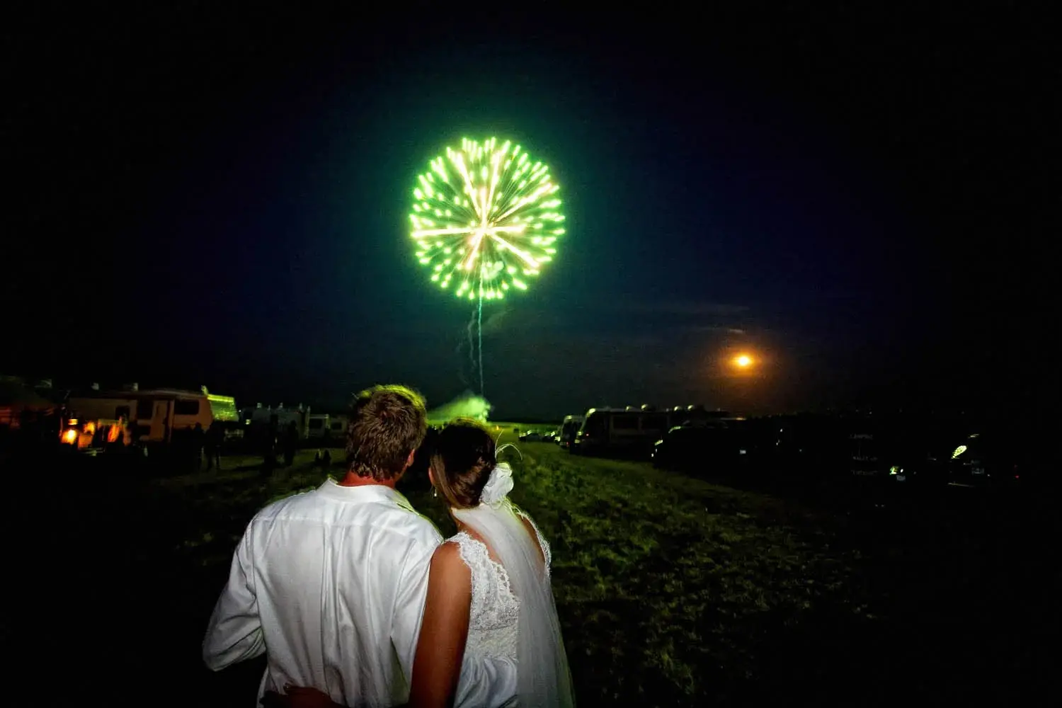 Couple watching green fireworks explode in the night sky from a field — Tim Larsen Photography, Brainerd Lakes MN