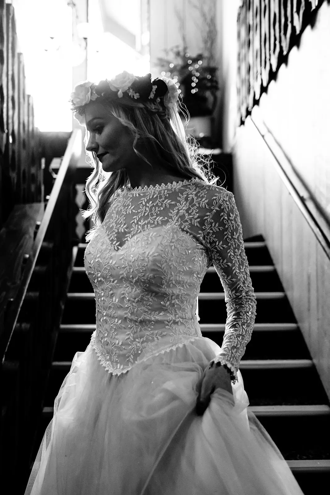 Black-and-white bride in a lace-sleeved dress on an old church staircase — Tim Larsen Photography, Brainerd Lakes MN