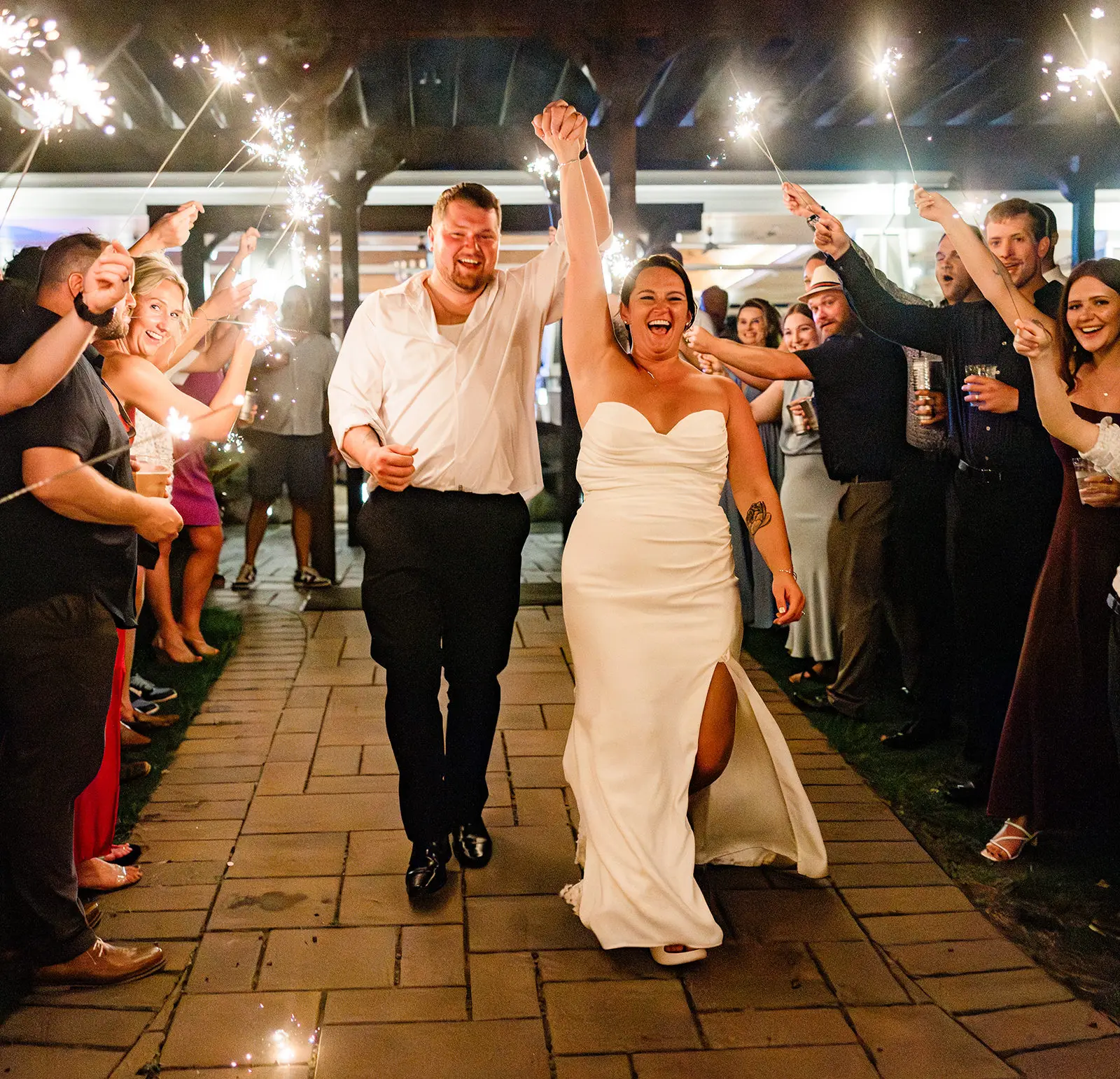 Grand exit through a sparkler line as the couple runs through a cheering crowd — Tim Larsen Photography, Brainerd Lakes MN