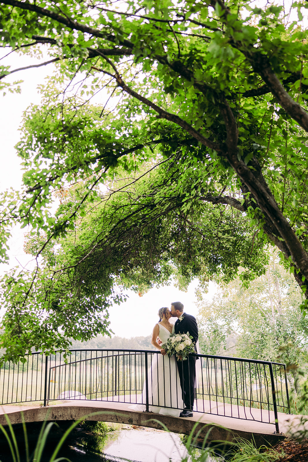 Couple kissing on a footbridge over the garden pond at Breezy Point Resort — Tim Larsen Photography, Brainerd Lakes MN