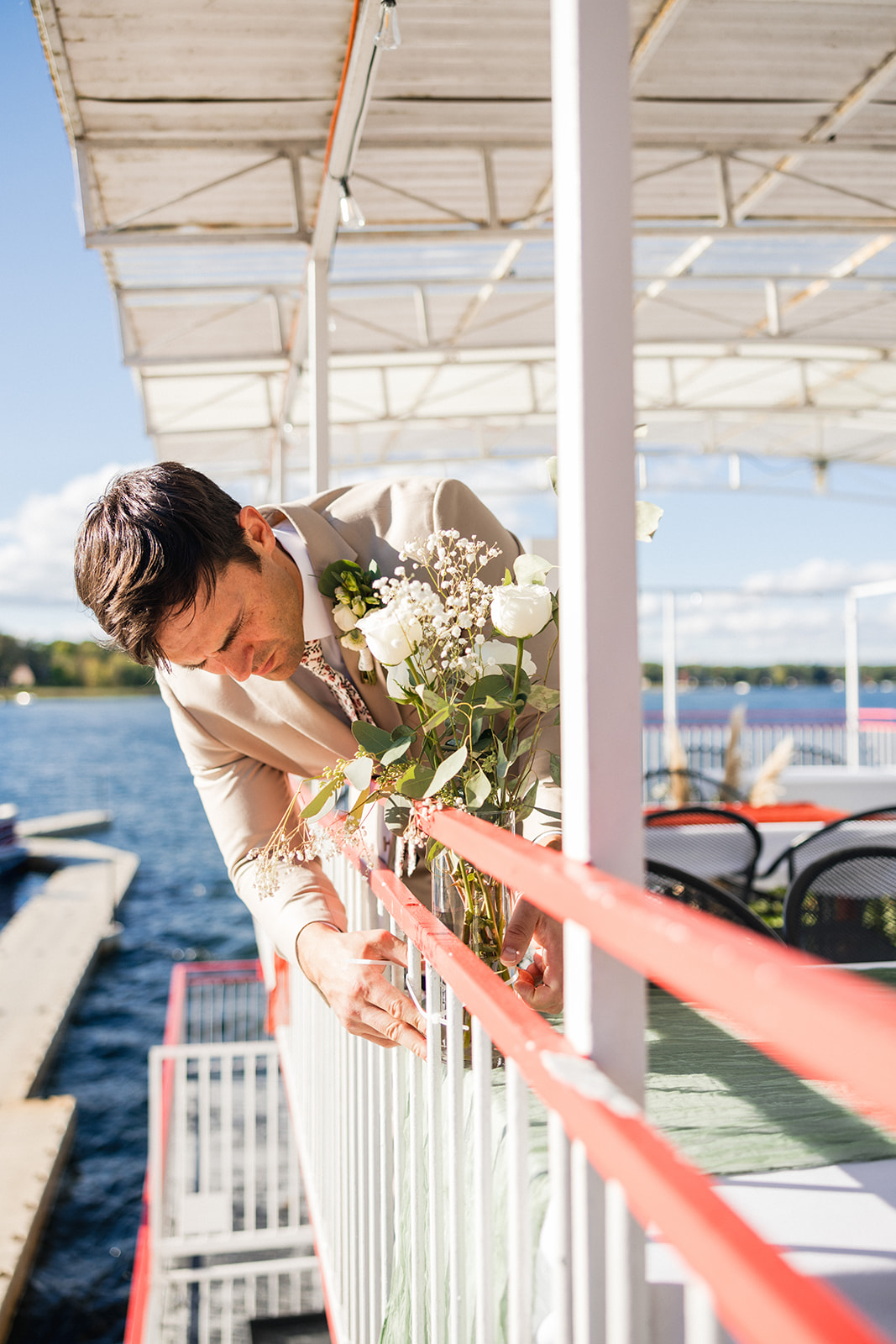 Bride with bouquet leaning over the railing of the Breezy Belle steamboat — Tim Larsen Photography, Brainerd Lakes MN