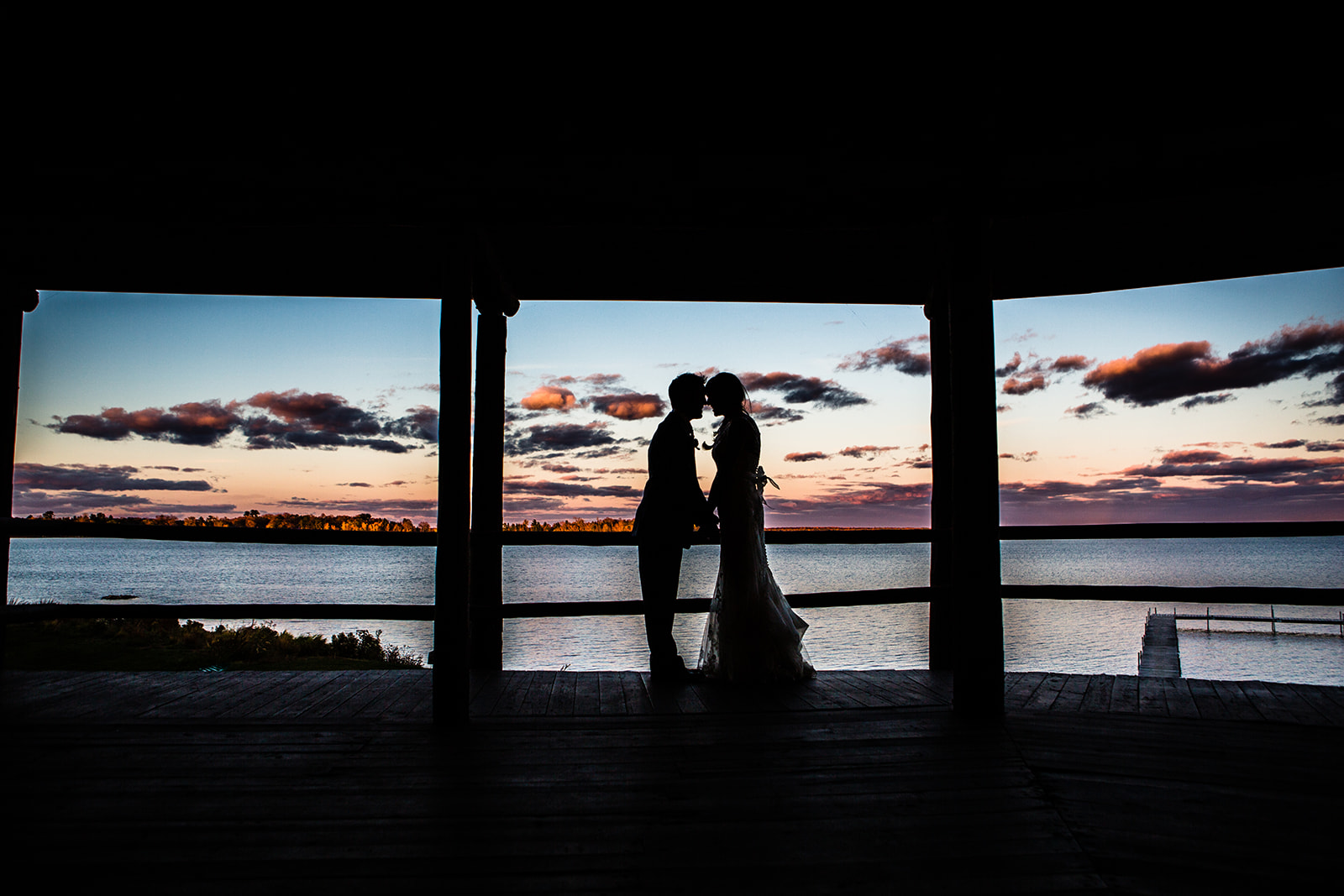Couple silhouette kissing in the gazebo at sunset — Pelican Lake behind them — Tim Larsen Photography, Brainerd Lakes MN