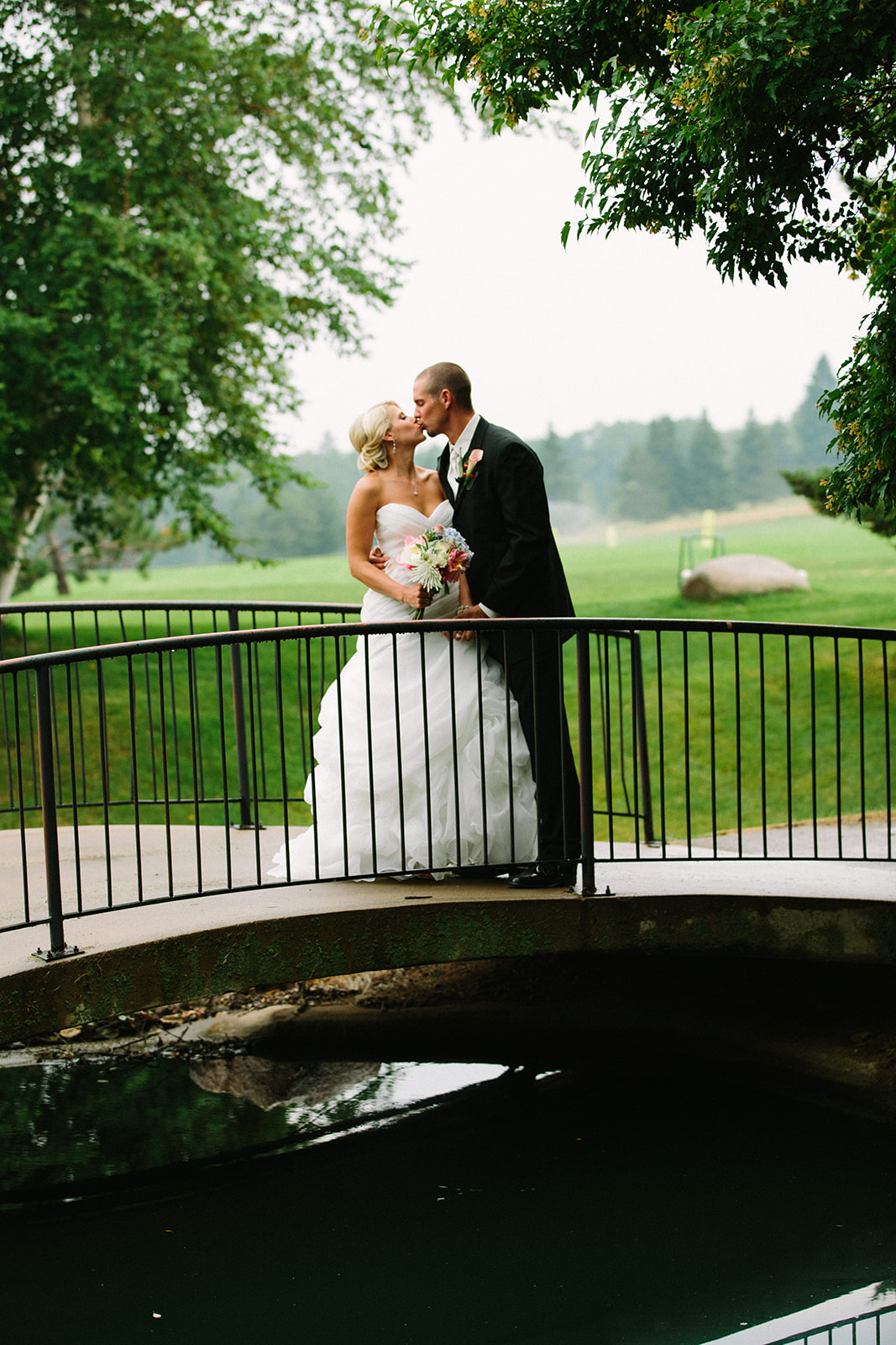 Couple kissing on the garden bridge with golf course behind — Breezy Point — Tim Larsen Photography, Brainerd Lakes MN