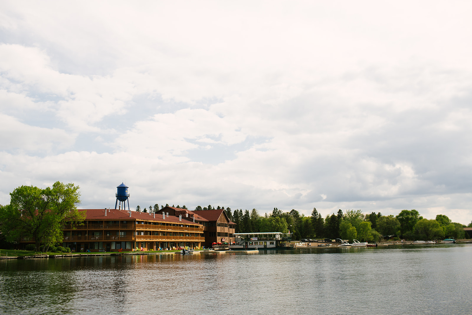 Breezy Point Resort from the water — log lodge, blue water tower, beach, and docks — Tim Larsen Photography, Brainerd Lakes MN