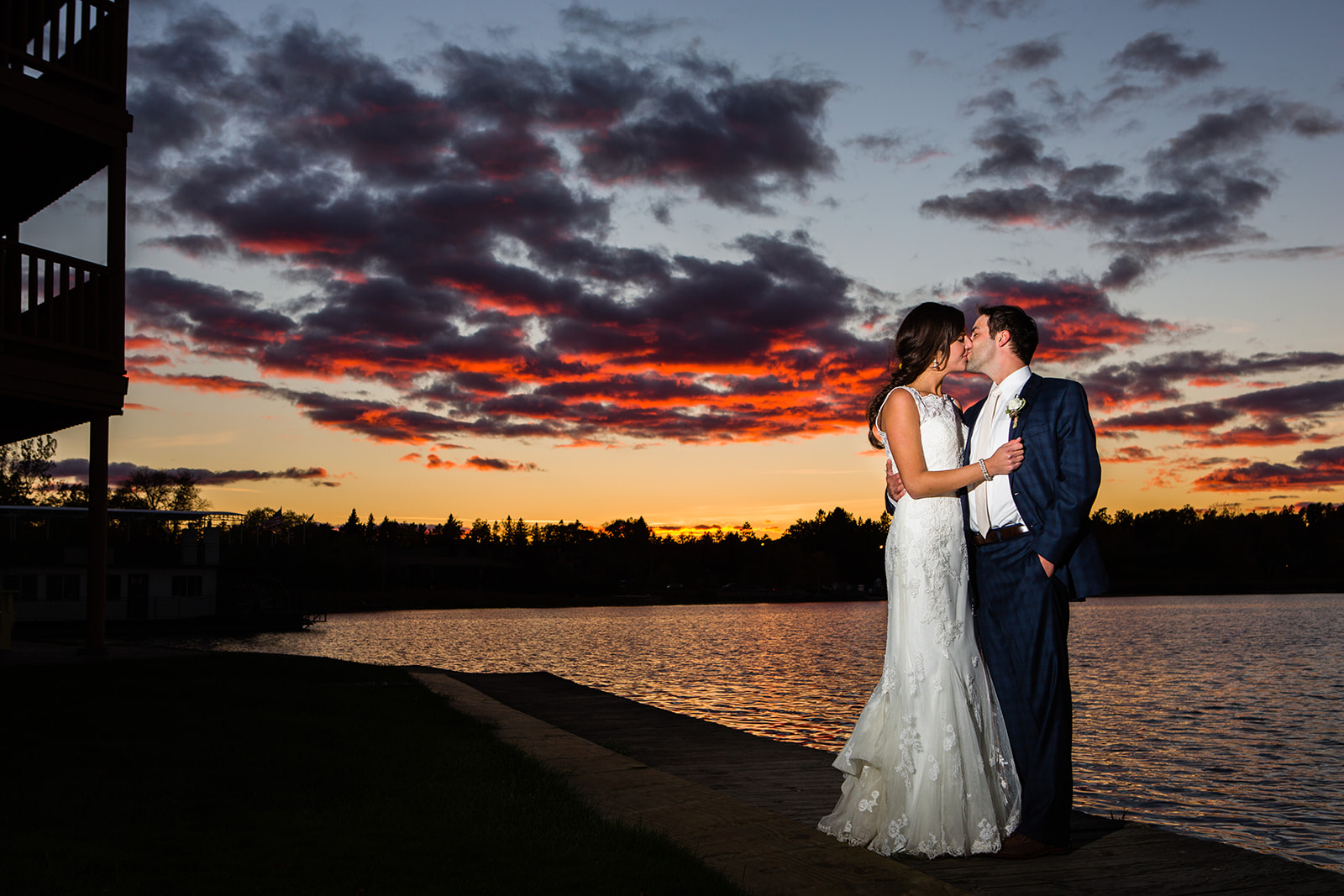 Couple kissing at sunset with dramatic red and purple clouds over Pelican Lake — Tim Larsen Photography, Brainerd Lakes MN