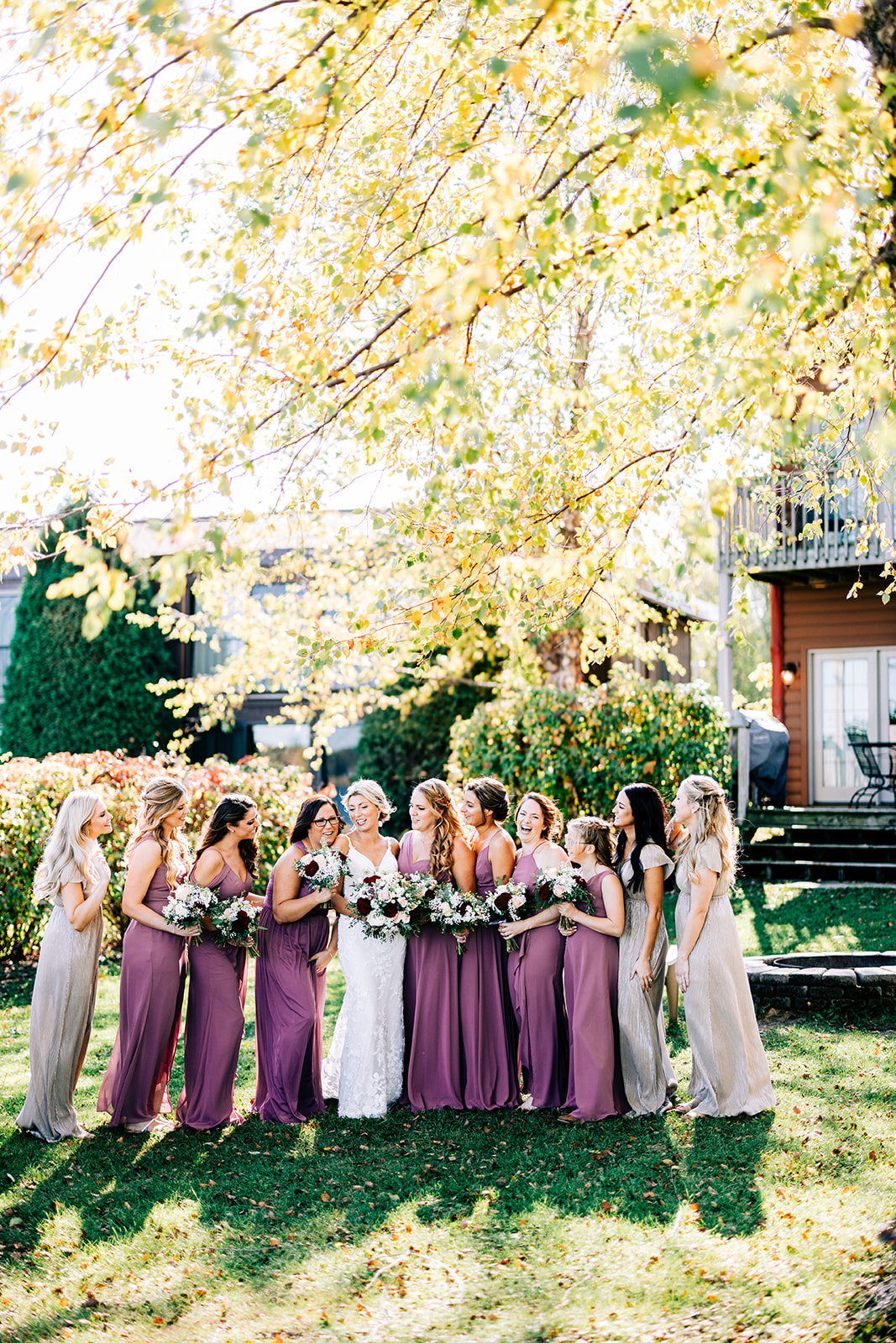 Bride with bridesmaids in mismatched purple and neutral dresses under fall birch trees — Tim Larsen Photography, Brainerd Lakes MN