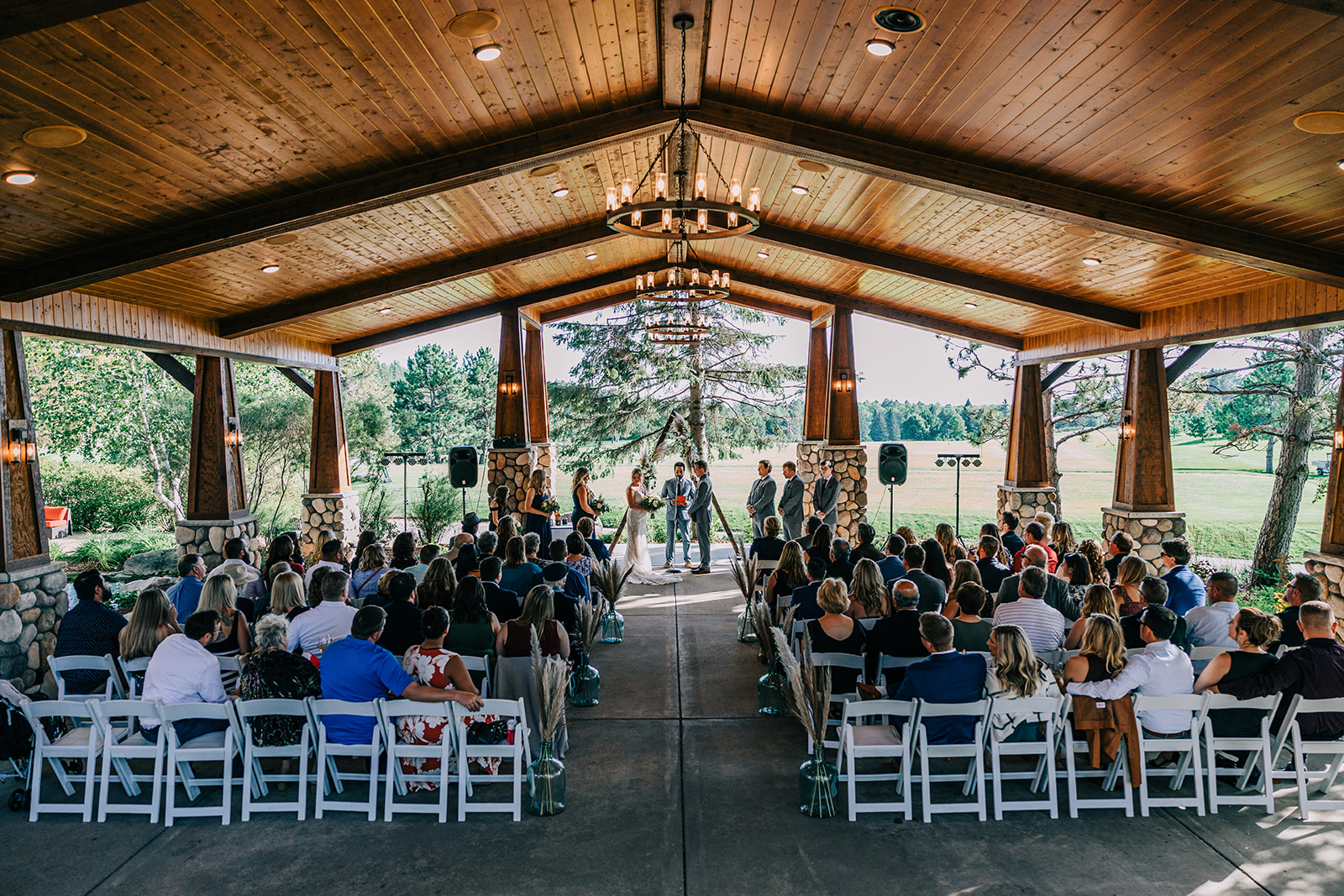 Ceremony in the Antlers Pavilion — timber ceiling, chandelier, and full house — Tim Larsen Photography, Brainerd Lakes MN