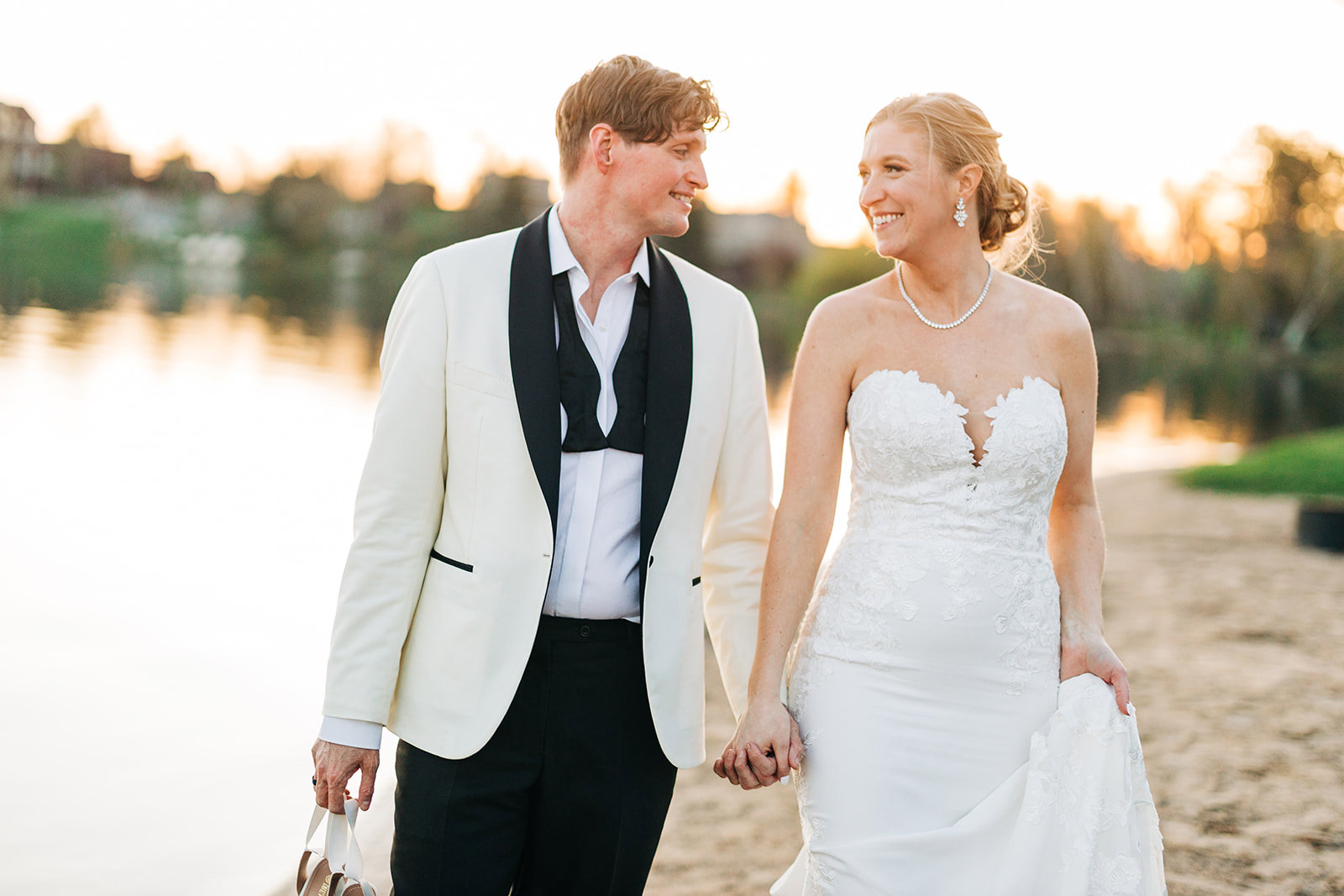 Couple walking on the beach at sunset — white tuxedo jacket and lace gown — Tim Larsen Photography, Brainerd Lakes MN