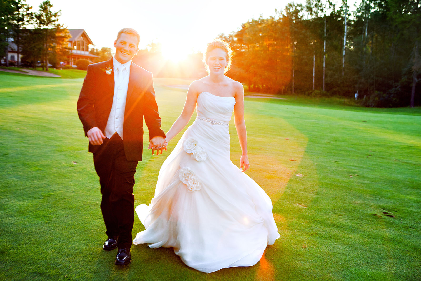 Couple running on the golf course at golden hour — sun flare and flowing gown — Tim Larsen Photography, Brainerd Lakes MN