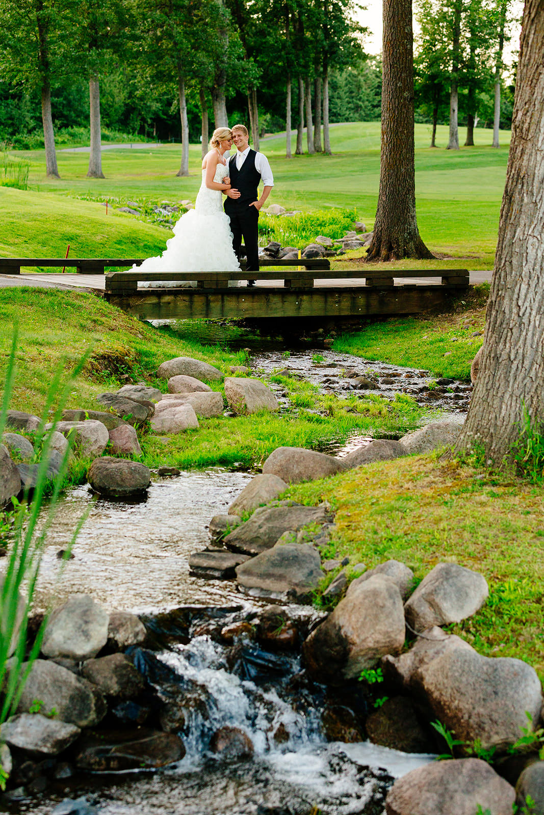 Couple on the bridge over the waterfall — Legacy Golf Course, green fairways — Tim Larsen Photography, Brainerd Lakes MN