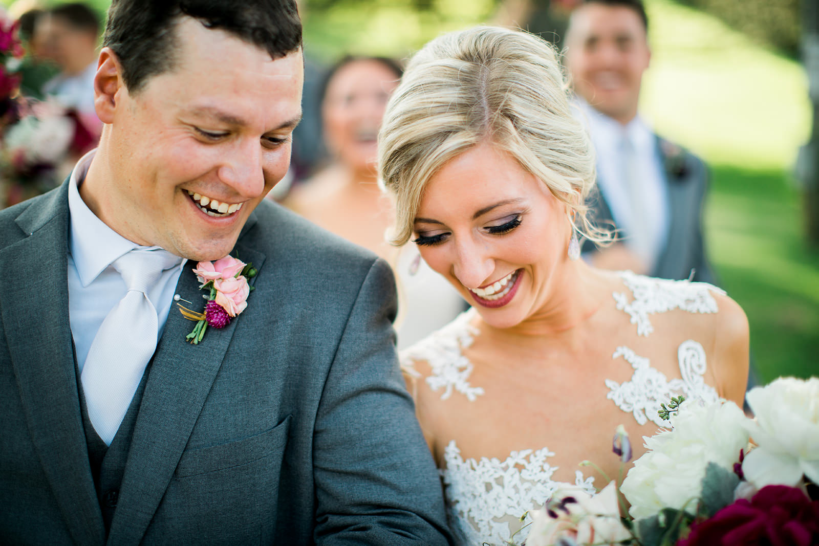 Couple laughing during the ceremony — lace gown, gray suit, close-up — Tim Larsen Photography, Brainerd Lakes MN