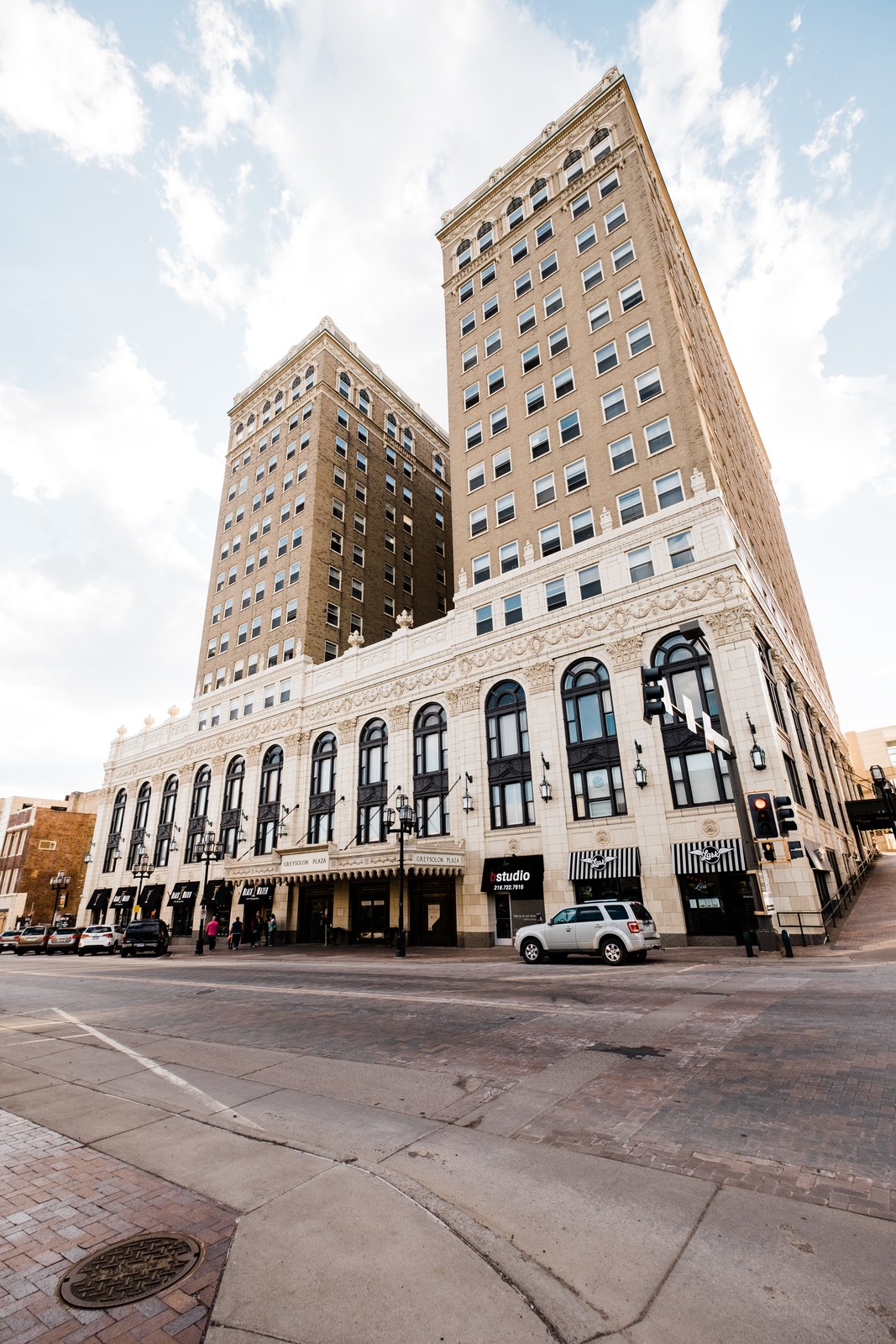 Wide low-angle of the historic Greysolon Plaza stone tower against soft sky in downtown Duluth — Tim Larsen Photography, Duluth MN