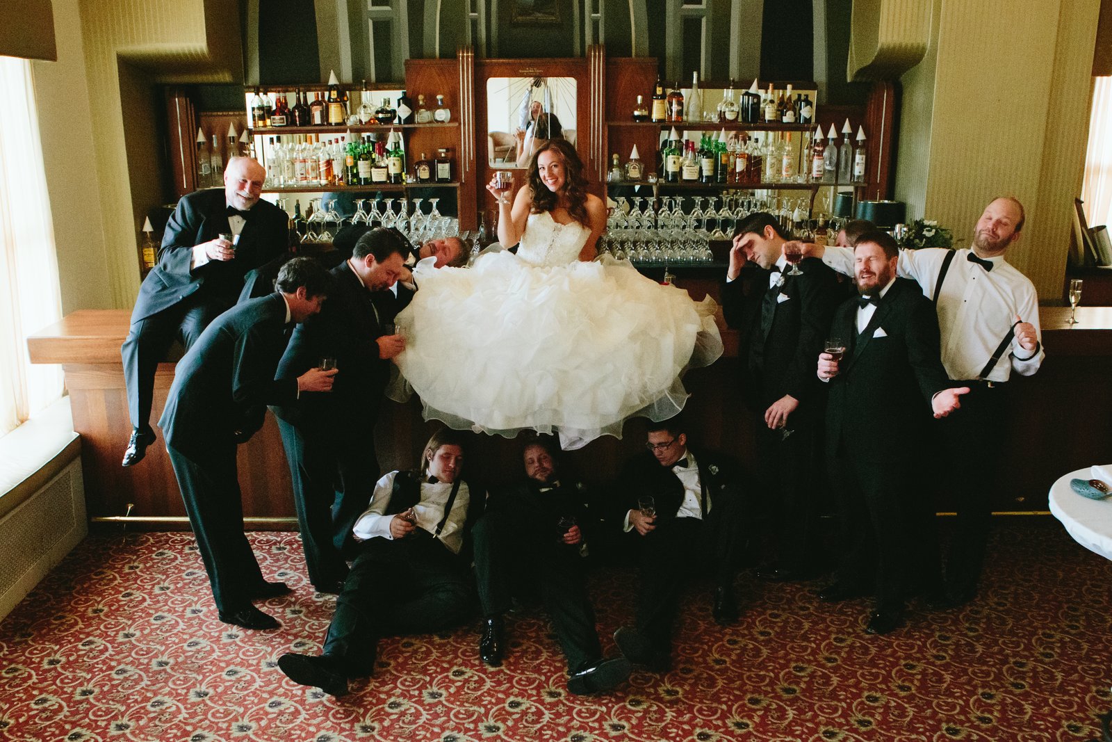 Bridal party in the historic Greysolon bar — playful candid frame, winter — Tim Larsen Photography, Duluth MN
