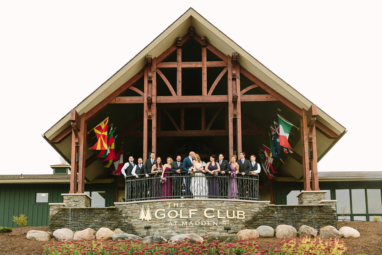 Full wedding party at the Golf Club at Madden's — timber-frame clubhouse entrance — Tim Larsen Photography, Brainerd Lakes MN