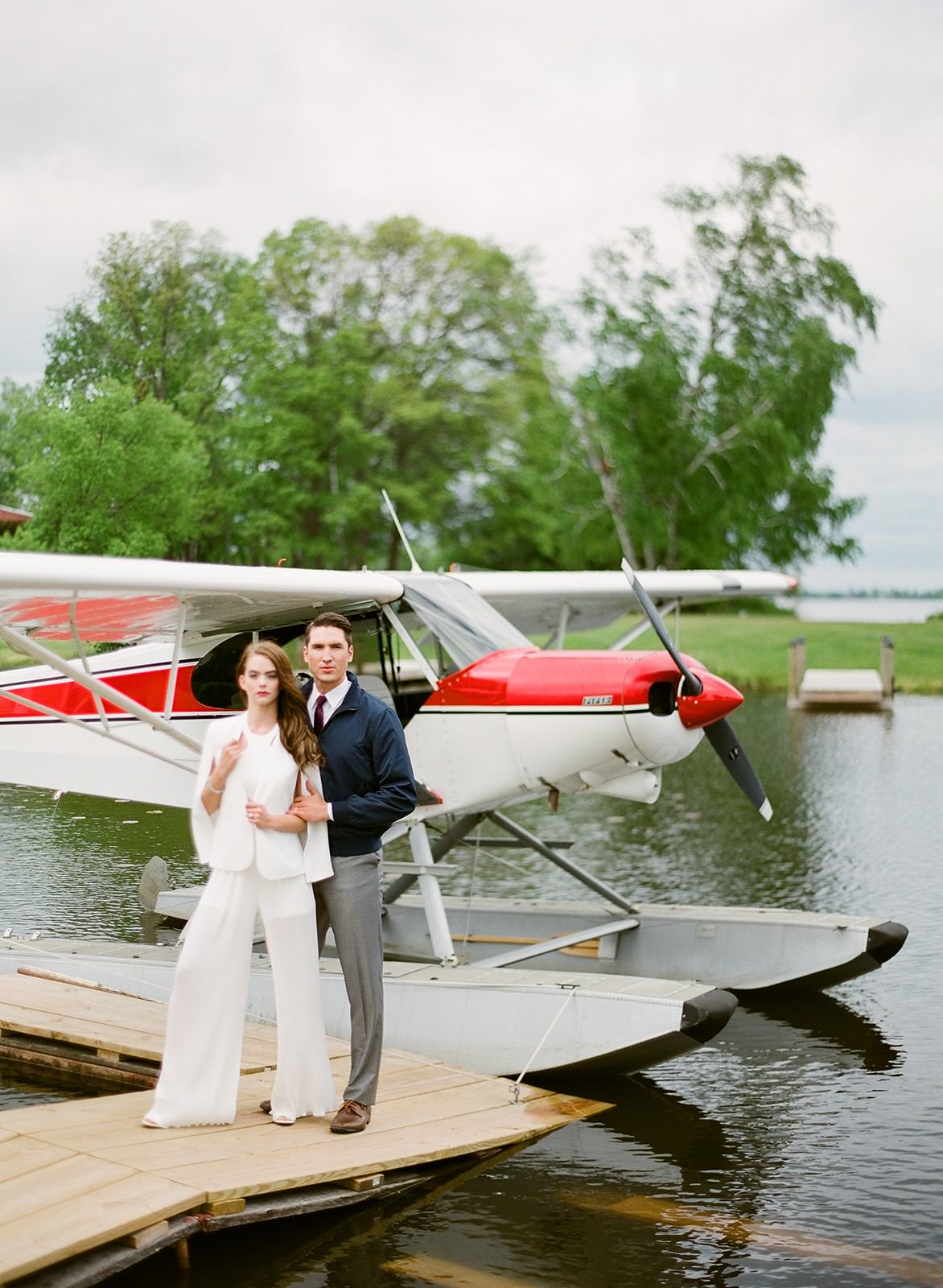 Couple standing by the red and white seaplane on the dock — Tim Larsen Photography, Brainerd Lakes MN