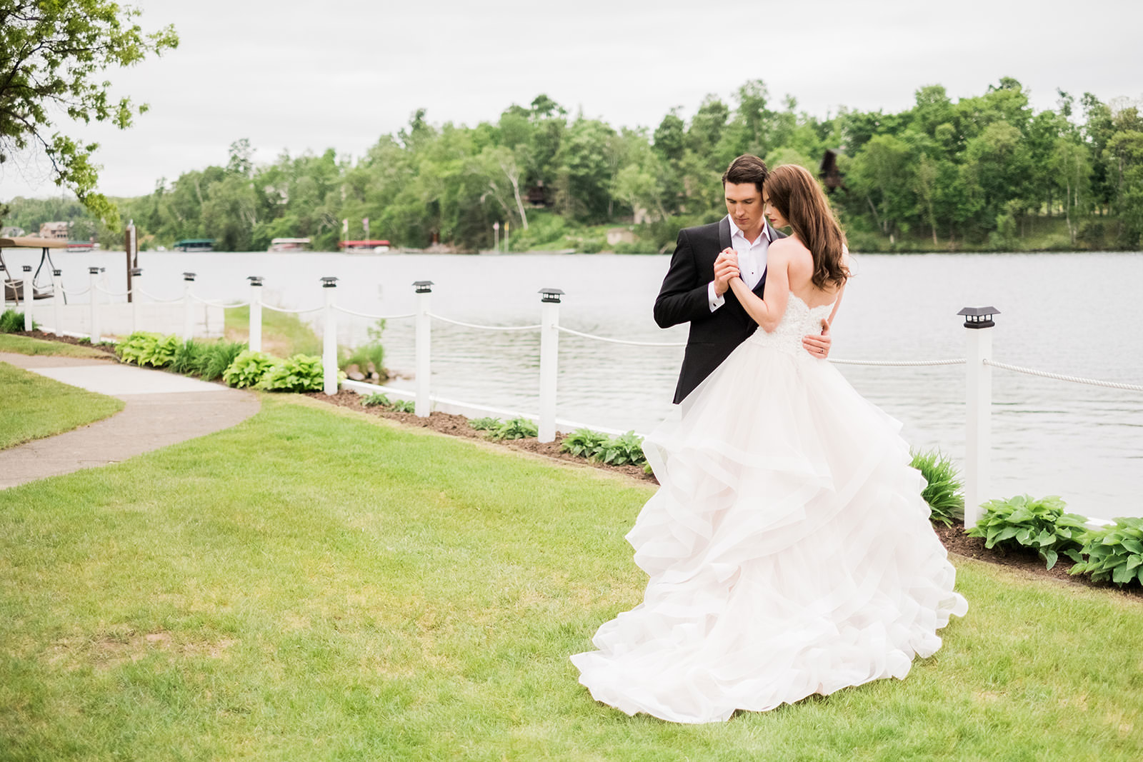 Couple's first dance on the lakeside lawn — dress flowing on the green grass — Tim Larsen Photography, Brainerd Lakes MN