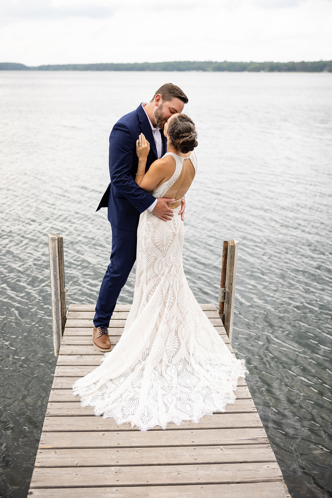 Couple dip kiss on the dock — lace train and navy suit on Big Trout Lake — Tim Larsen Photography, Brainerd Lakes MN