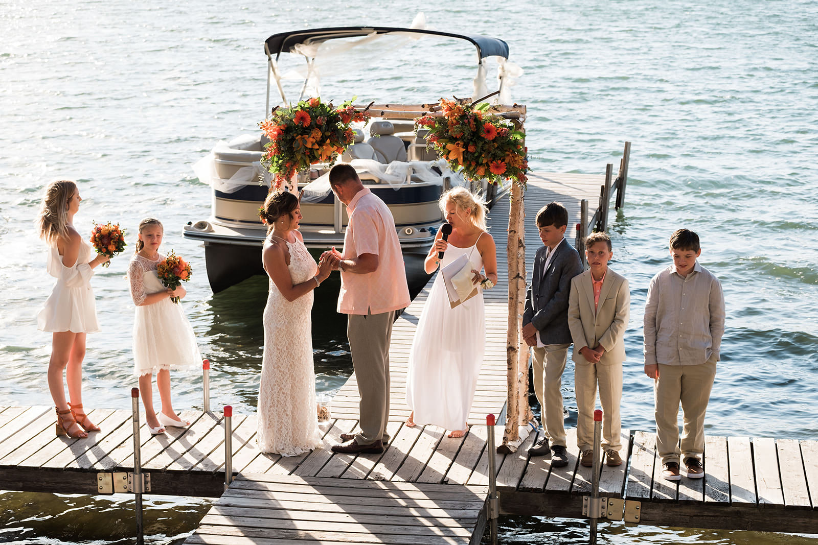Intimate dock ceremony with pontoon boat and floral arch — Big Trout Lake — Tim Larsen Photography, Brainerd Lakes MN
